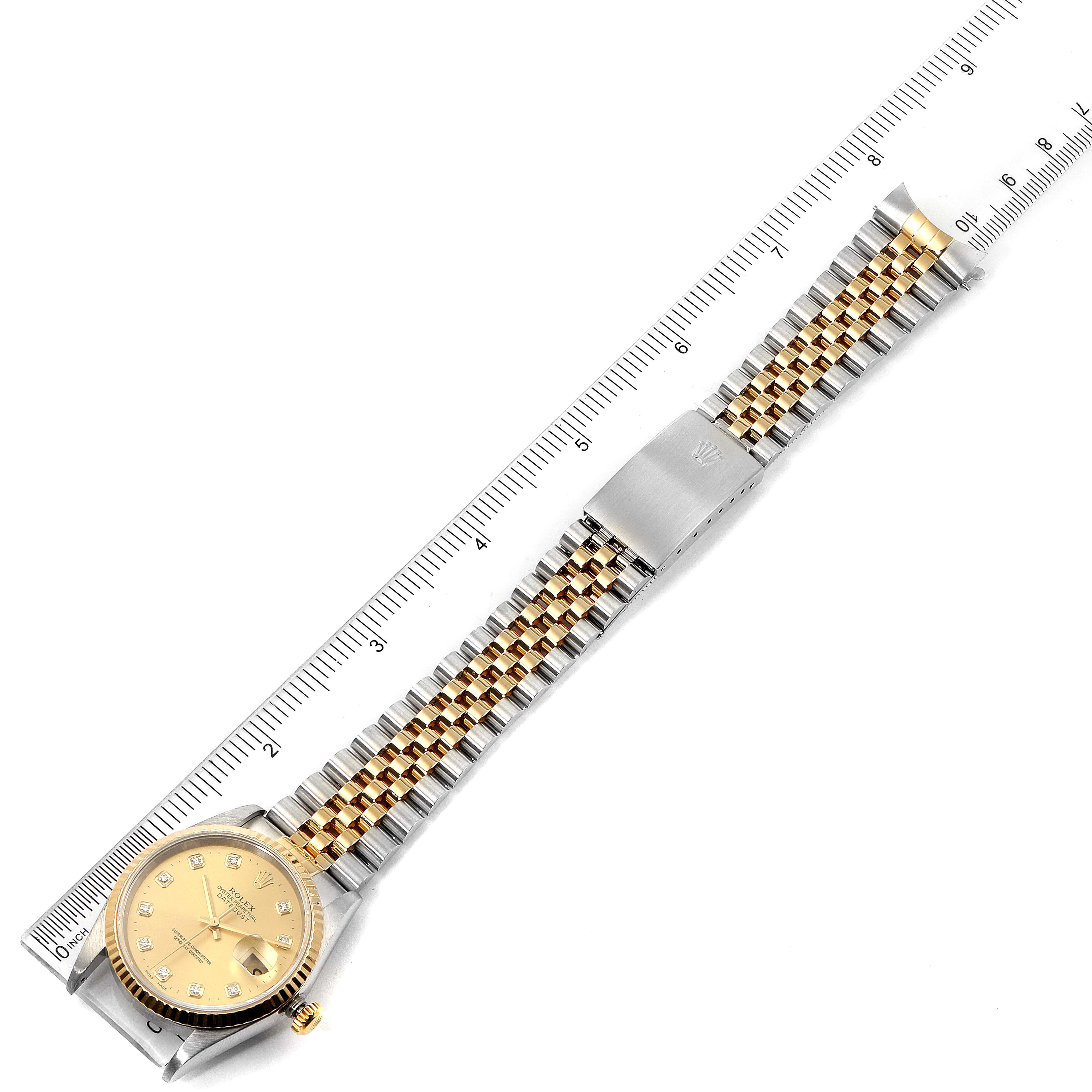 The image shows a top view of the Rolex Datejust 16233 Men's Steel and Gold (two tone) Champagne Dial 16233 Men's Steel and Gold (two tone) Champagne Dial watch, featuring the face, bracelet, and clasp against a ruler.