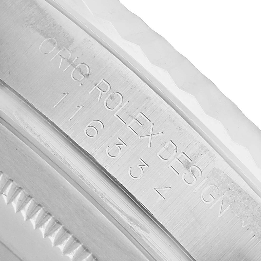 The image shows an angled close-up of the inner bezel of a Rolex Datejust 41 116334 Men's Stainless Steel Blue Dial, highlighting engraved text and numerical markings.