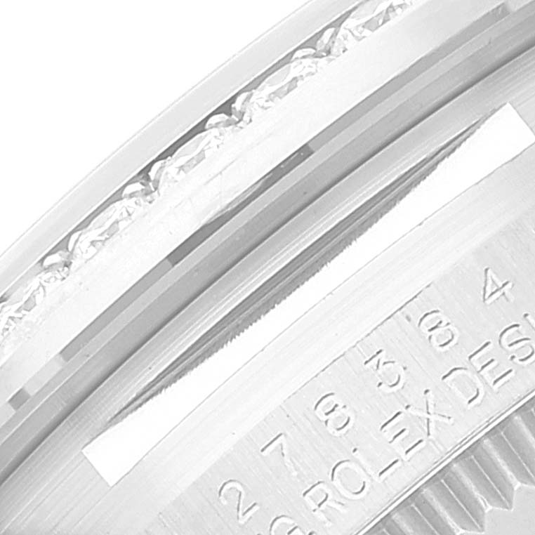 This image shows a close-up view of a Rolex Mid-Size 278384 Women's Stainless Steel Purple Dial 278384 Women's Stainless Steel Purple Dial model's case with visible text engravings.