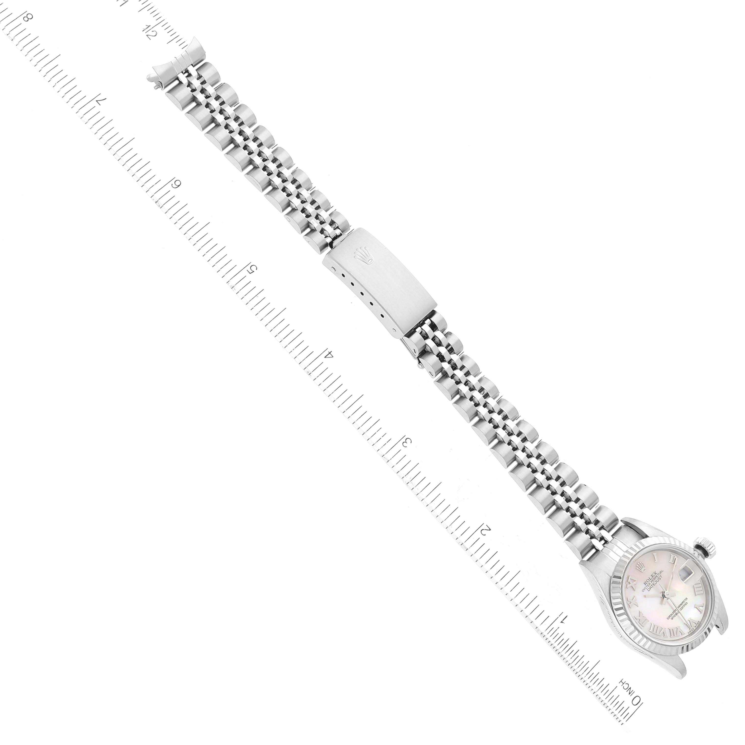 The image shows a Rolex Datejust 79174 Women's Stainless Steel Mother of Pearl Dial 79174 Women's Stainless Steel Mother of Pearl Dial watch from a top-down angle, displaying the face, bracelet, and clasp, alongside a ruler for measurement.