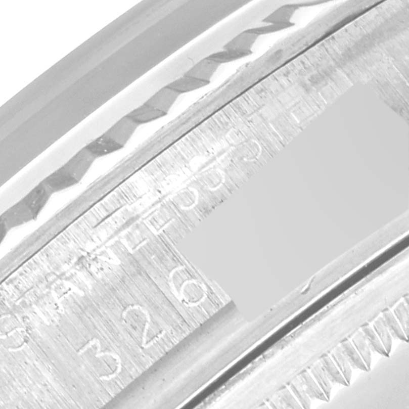 This close-up image of a Rolex Vintage Collection 1601 Men's Stainless Steel Silver Dial 1601 Men's Stainless Steel Silver Dial watch shows the engraved serial number and part of the watch case's bezel.