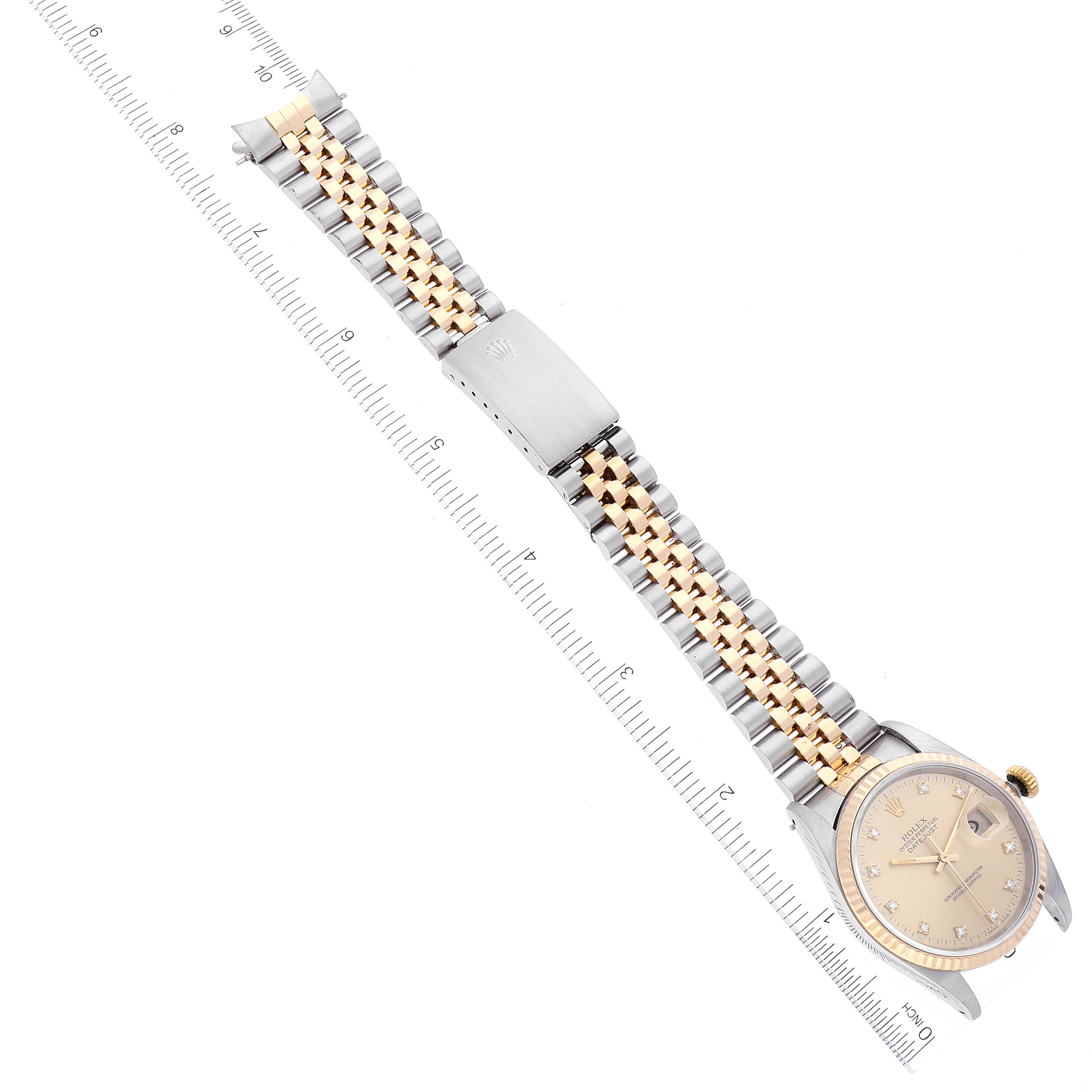 The image shows a Rolex Datejust 16233 Men's Steel and Gold (two tone) Champagne Dial 16233 Men's Steel and Gold (two tone) Champagne Dial watch at an oblique angle, displaying its face and two-tone bracelet next to a ruler for scale.