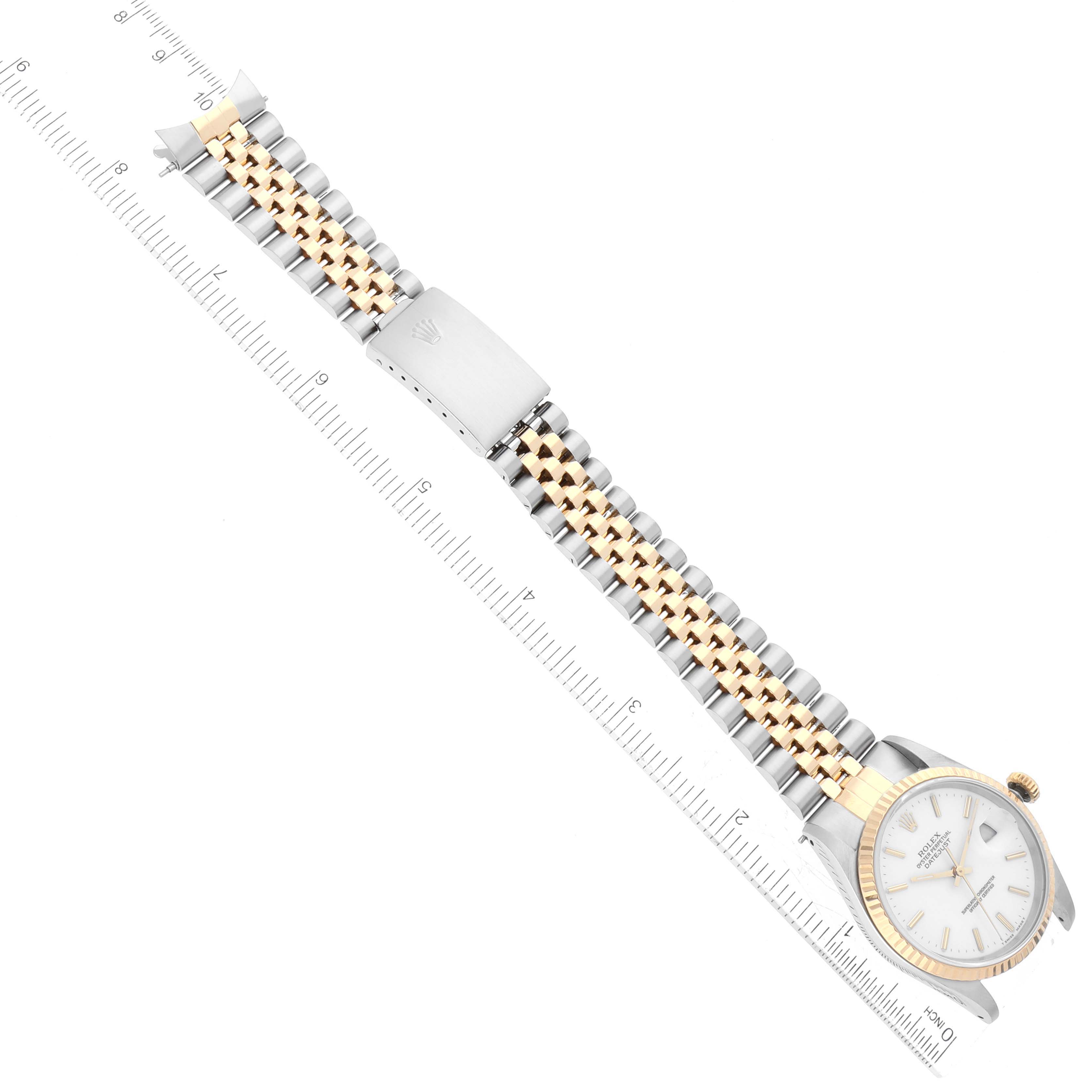 The image shows the top view of a Rolex Datejust 16233 Men's Steel and Gold (two tone) White Dial 16233 Men's Steel and Gold (two tone) White Dial watch, displaying the face, bezel, bracelet, and clasp along a ruler.