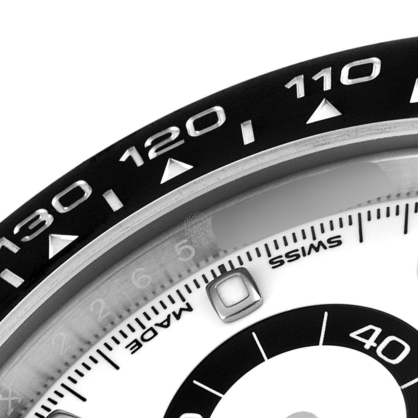 The image shows a close-up of the bezel and part of the dial of the Rolex Daytona 116500 Men's Stainless Steel White Dial 116500 Men's Stainless Steel White Dial watch, including the tachymeter scale and part of the register.