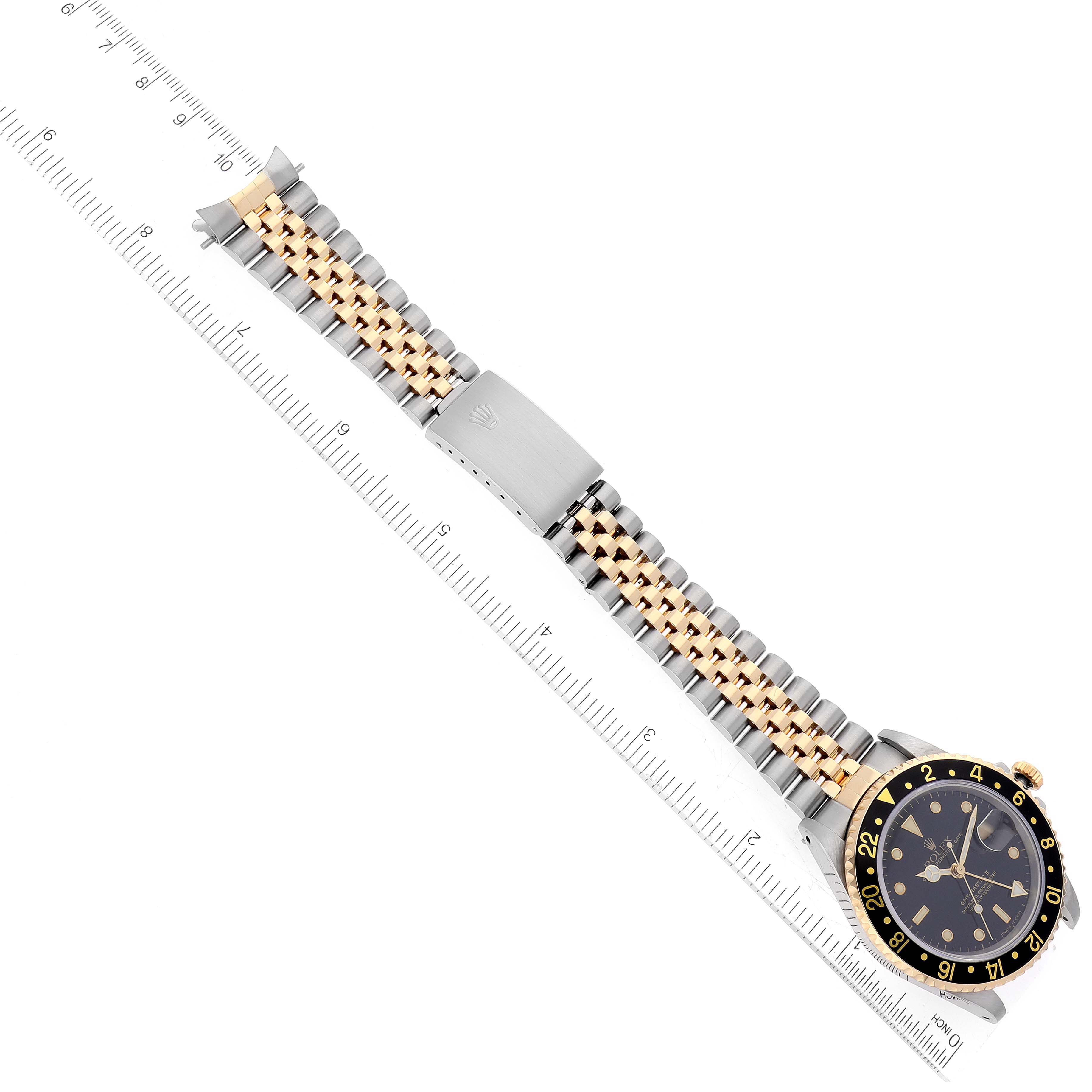 The Rolex GMT-Master 16713 Men's Steel and Gold (two tone) Black Dial 16713 Men's Steel and Gold (two tone) Black Dial watch is shown laid flat with the face angled slightly sideways and the bracelet fully extended.
