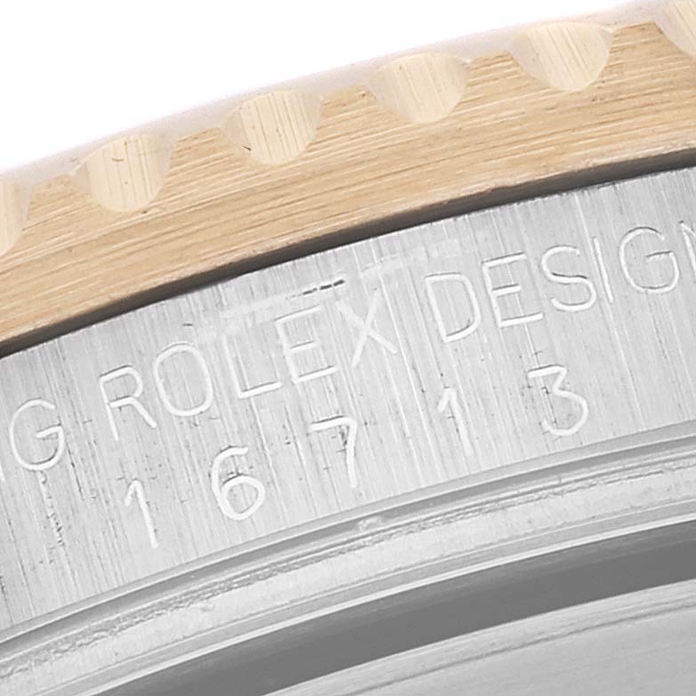 This image shows a close-up of the bezel and case of a Rolex GMT-Master 16713 Men's Steel and Gold (two tone) Black Dial 16713 Men's Steel and Gold (two tone) Black Dial watch, highlighting the engraved model number and brand name.
