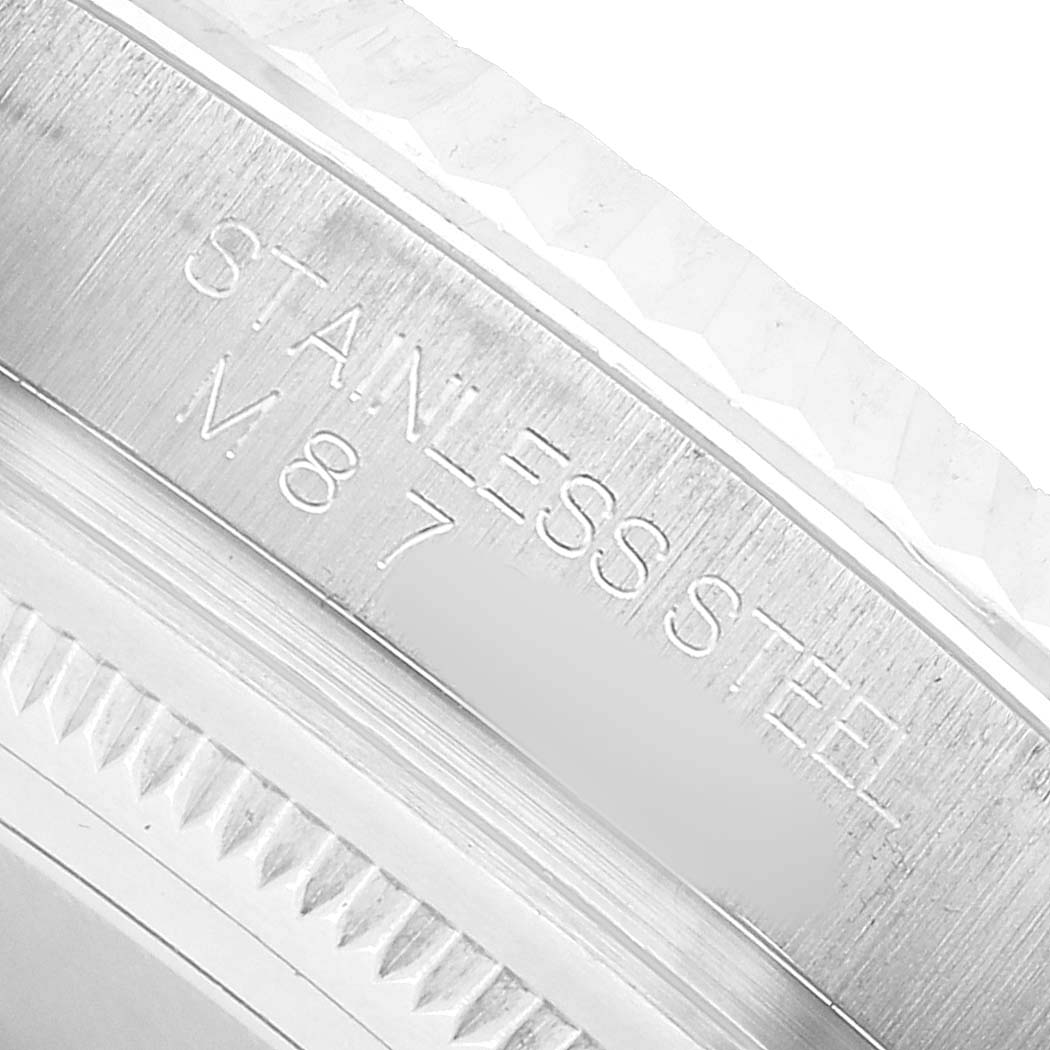 The image shows a close-up of the side of the stainless steel case of the Rolex Oyster Perpetual 116034 Men's Stainless Steel White Dial, highlighting engraved text.