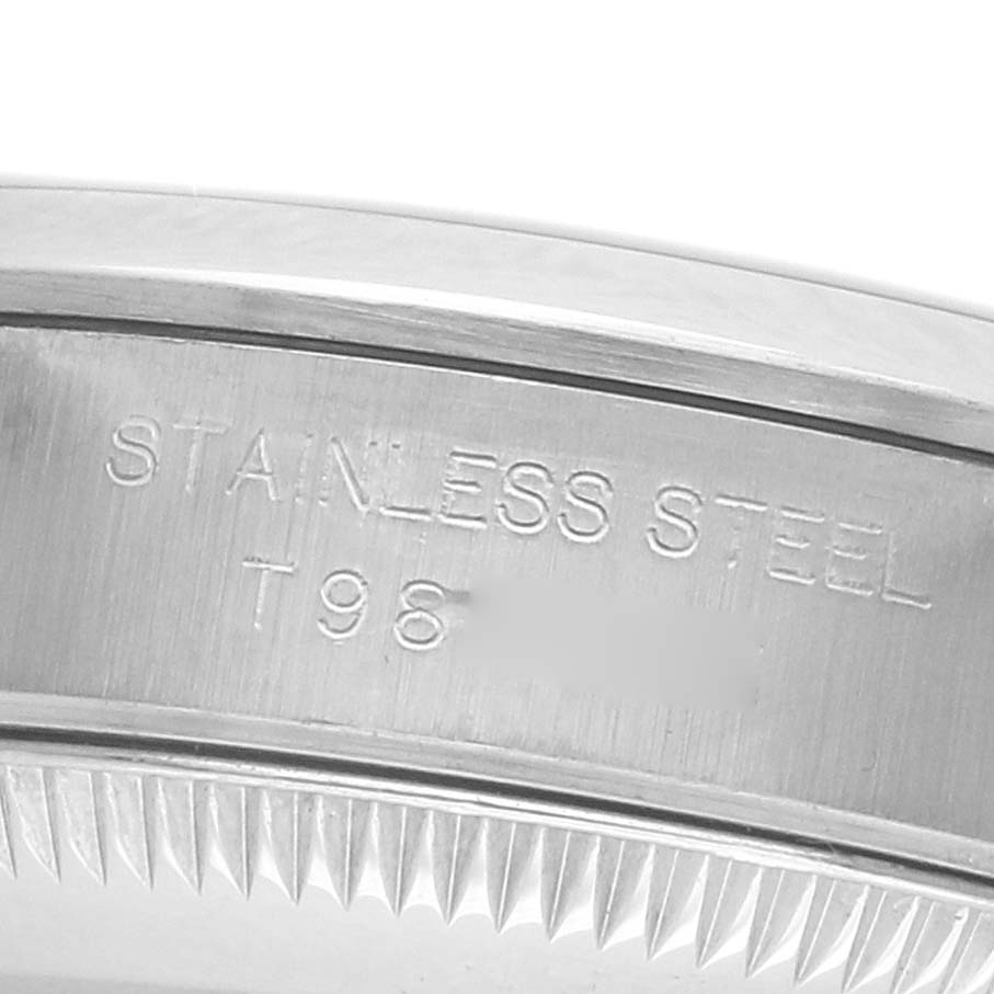 The image shows a close-up of the side of the Rolex Oyster Perpetual 67180 Women's Stainless Steel Blue Dial watch case, highlighting the "STAINLESS STEEL" engraving.