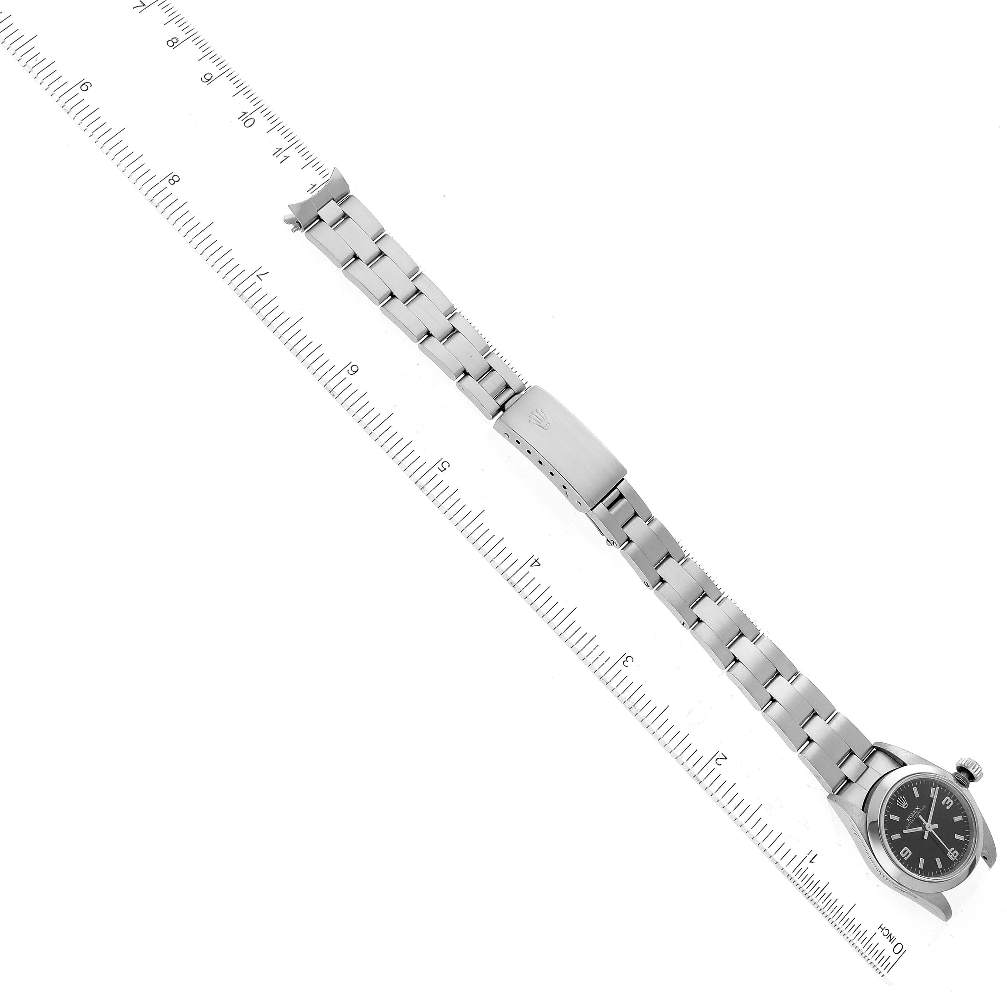 The Rolex Oyster Perpetual 67180 Women's Stainless Steel Black Dial 67180 Women's Stainless Steel Black Dial watch is shown from a top-down angle, displaying the face, bracelet, and clasp.