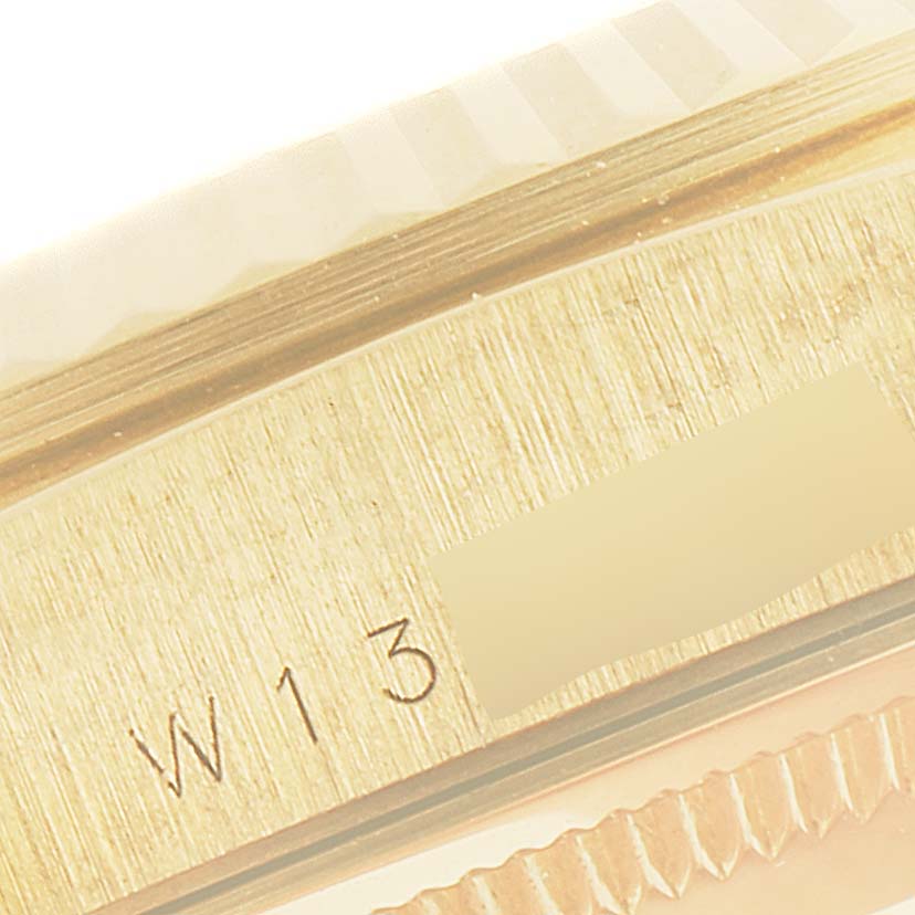 The image shows a close-up view of the engraved serial number and part of the fluted bezel on a Rolex President 18238 Men's Yellow Gold Champagne Dial 18238 Men's Yellow Gold Champagne Dial model watch.