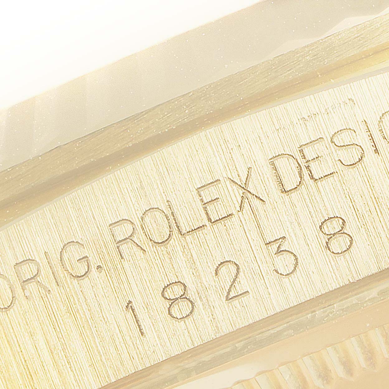 This image shows a close-up of the engraved serial number and the edge of a Rolex President 18238 Men's Yellow Gold Champagne Dial 18238 Men's Yellow Gold Champagne Dial model watch case, highlighting the brand.