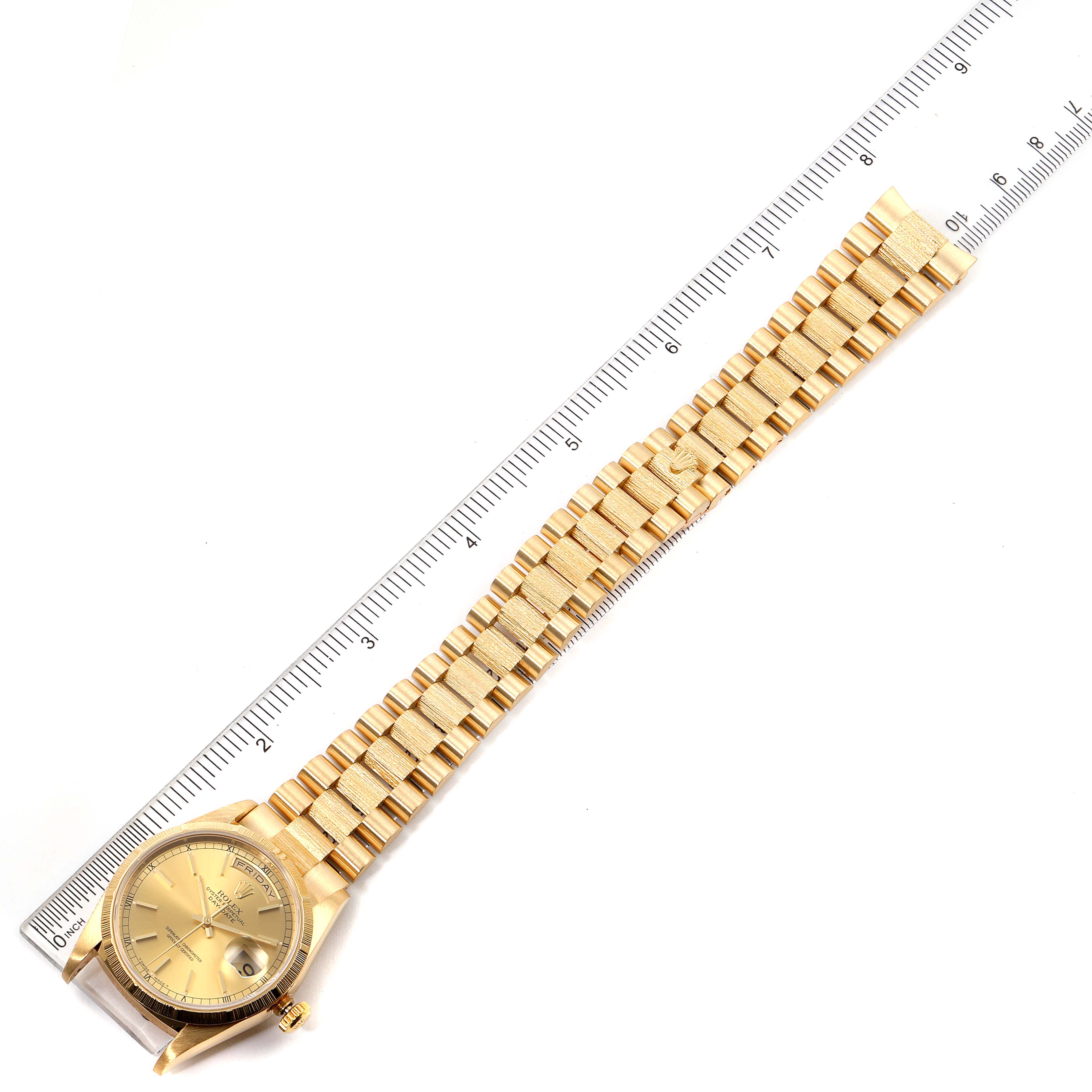 The image shows a top view of a Rolex President 18248 Men
s Yellow Gold Champagne Dial 18248 Men
s Yellow Gold Champagne Dial model watch, highlighting its gold bracelet and face with a ruler for scale.
