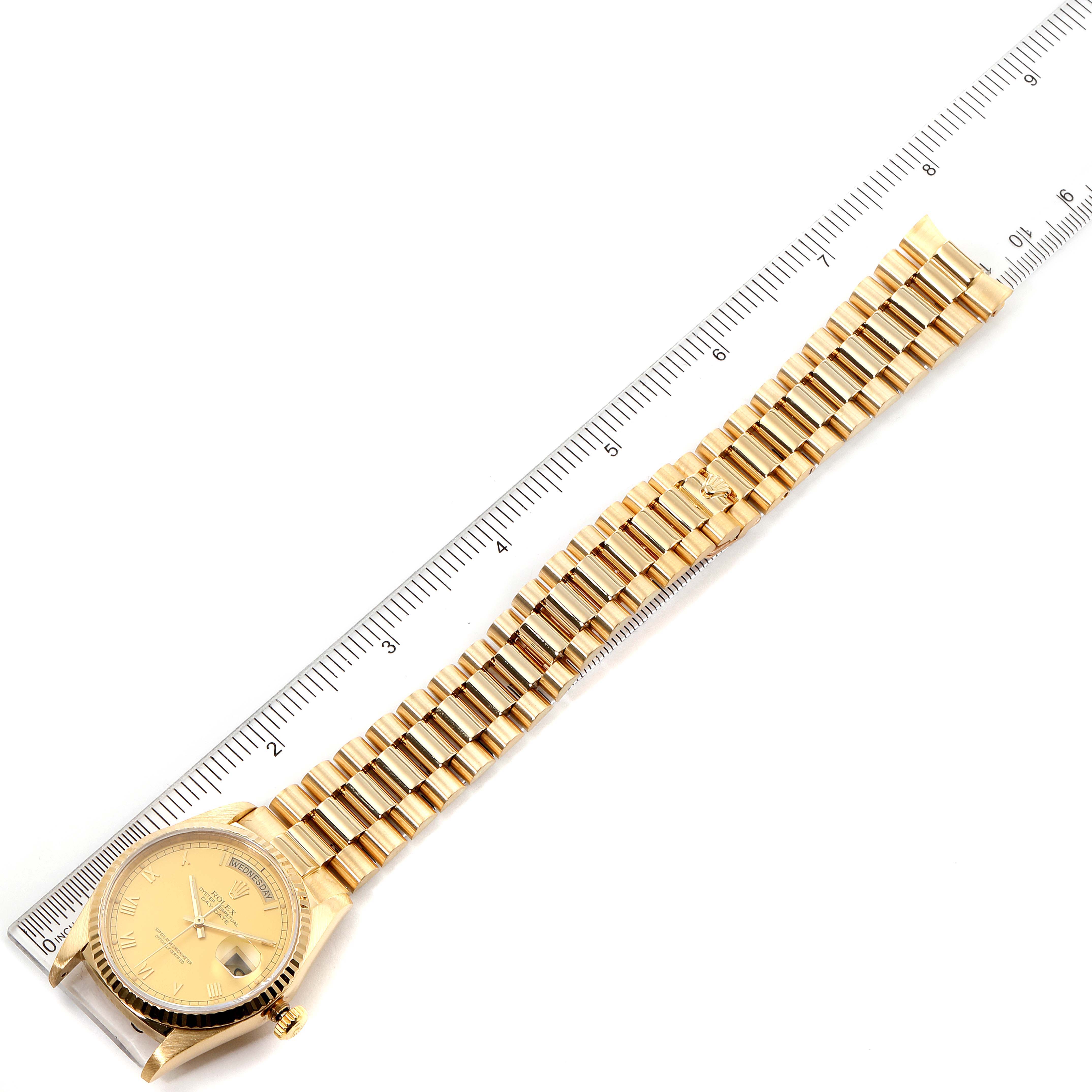 This image shows a Rolex President 18238 Men's Yellow Gold Champagne Dial 18238 Men's Yellow Gold Champagne Dial watch, laid flat, with its gold bracelet and face aligned next to a ruler.