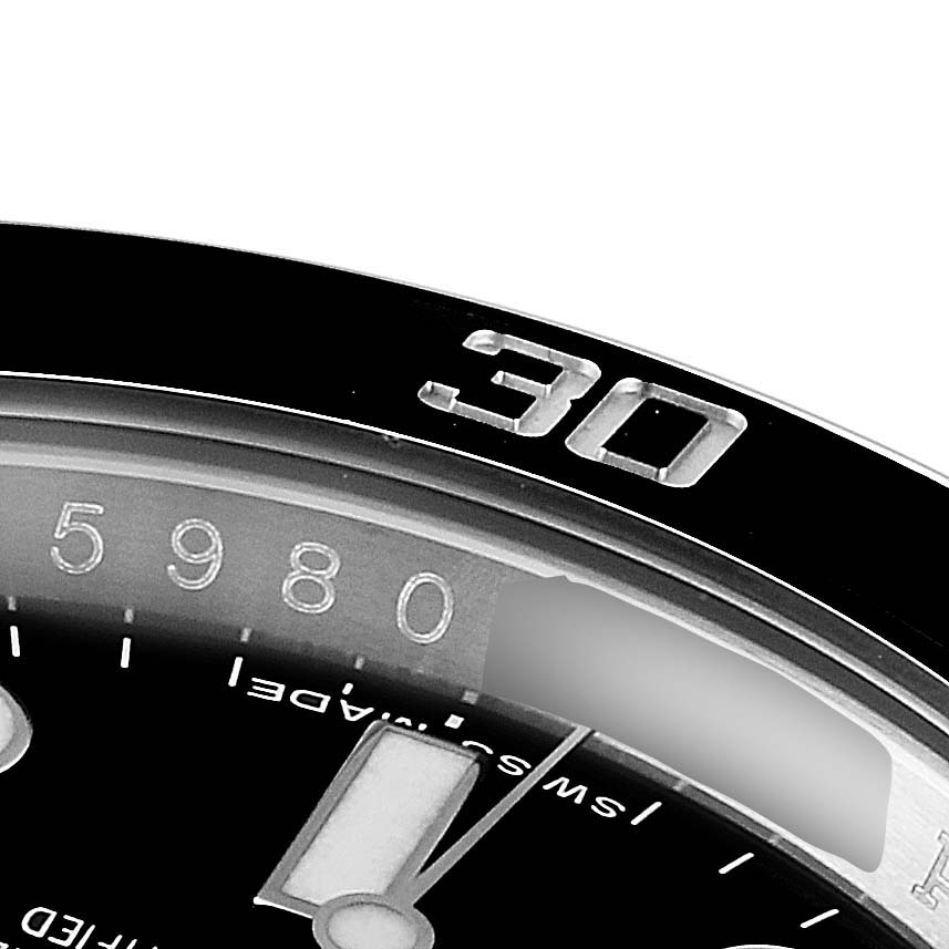 This image shows a close-up of the bezel and a portion of the dial of a Rolex Submariner 114060 Men's Stainless Steel Black Dial 114060 Men's Stainless Steel Black Dial watch.
