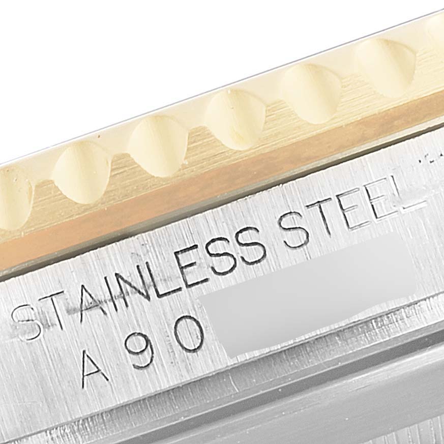 Close-up of the side view showing the engraved "STAINLESS STEEL" text and part of the bezel of a Rolex Submariner 16613 Men's Steel and Gold (two tone) Blue Dial 16613 Men's Steel and Gold (two tone) Blue Dial.