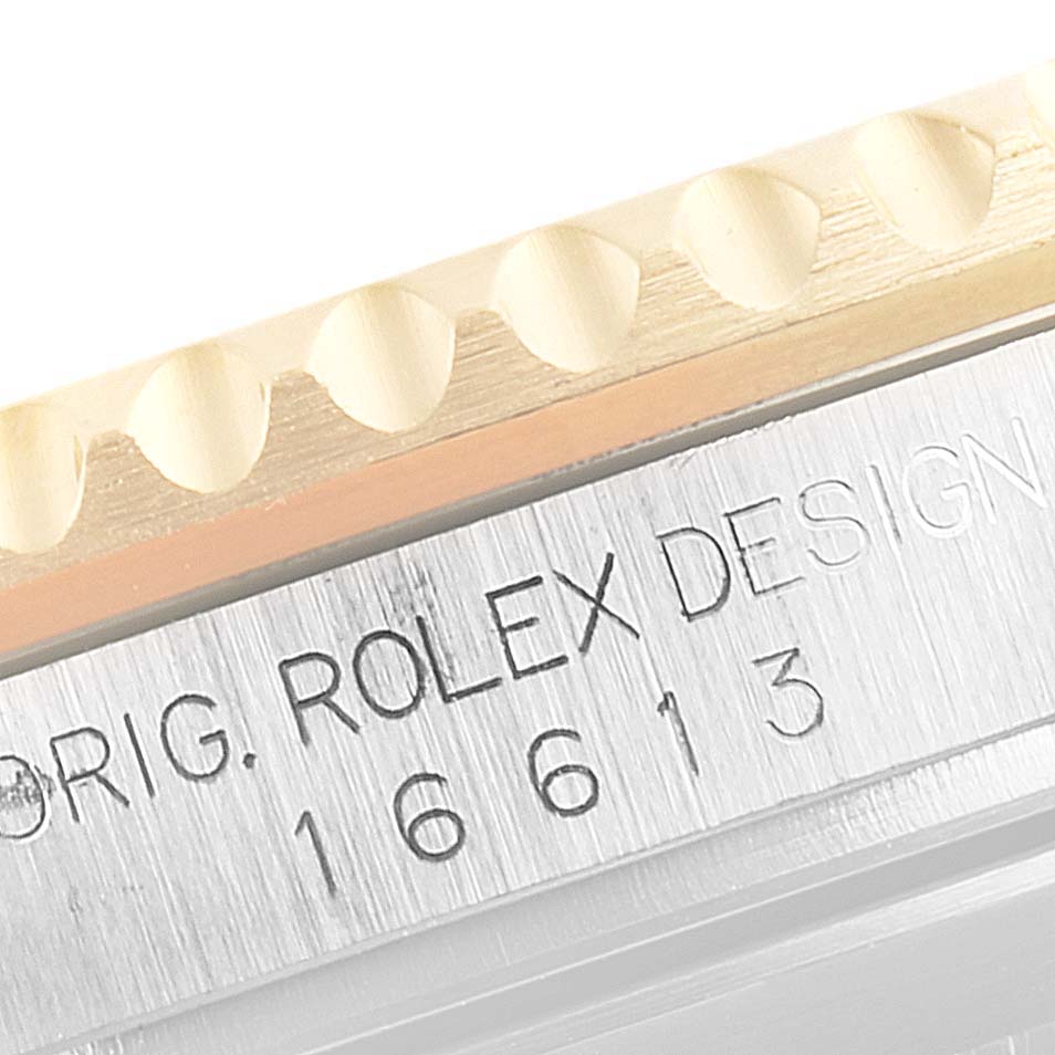 This image shows a close-up angle that captures the engraved model number "16613" and "Orig. Rolex Design" on the edge of the Rolex Submariner 16613 Men's Steel and Gold (two tone) Blue Dial 16613 Men's Steel and Gold (two tone) Blue Dial watch.