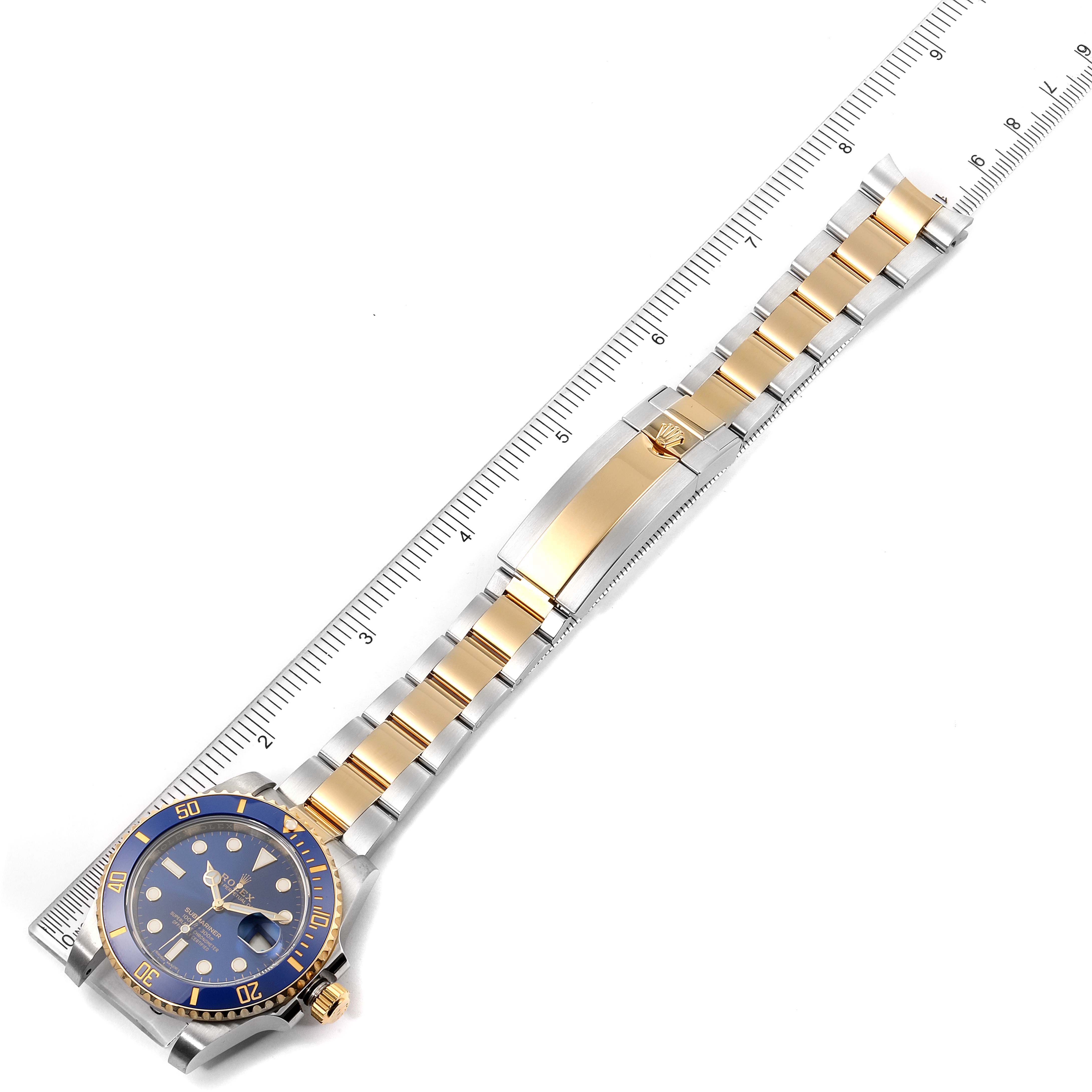 The Rolex Submariner 116613 Men's Steel and Gold (two tone) Blue Dial 116613 Men's Steel and Gold (two tone) Blue Dial watch is shown from a top-down angle, displaying the blue dial, gold bezel, and bi-metallic bracelet with clasp.