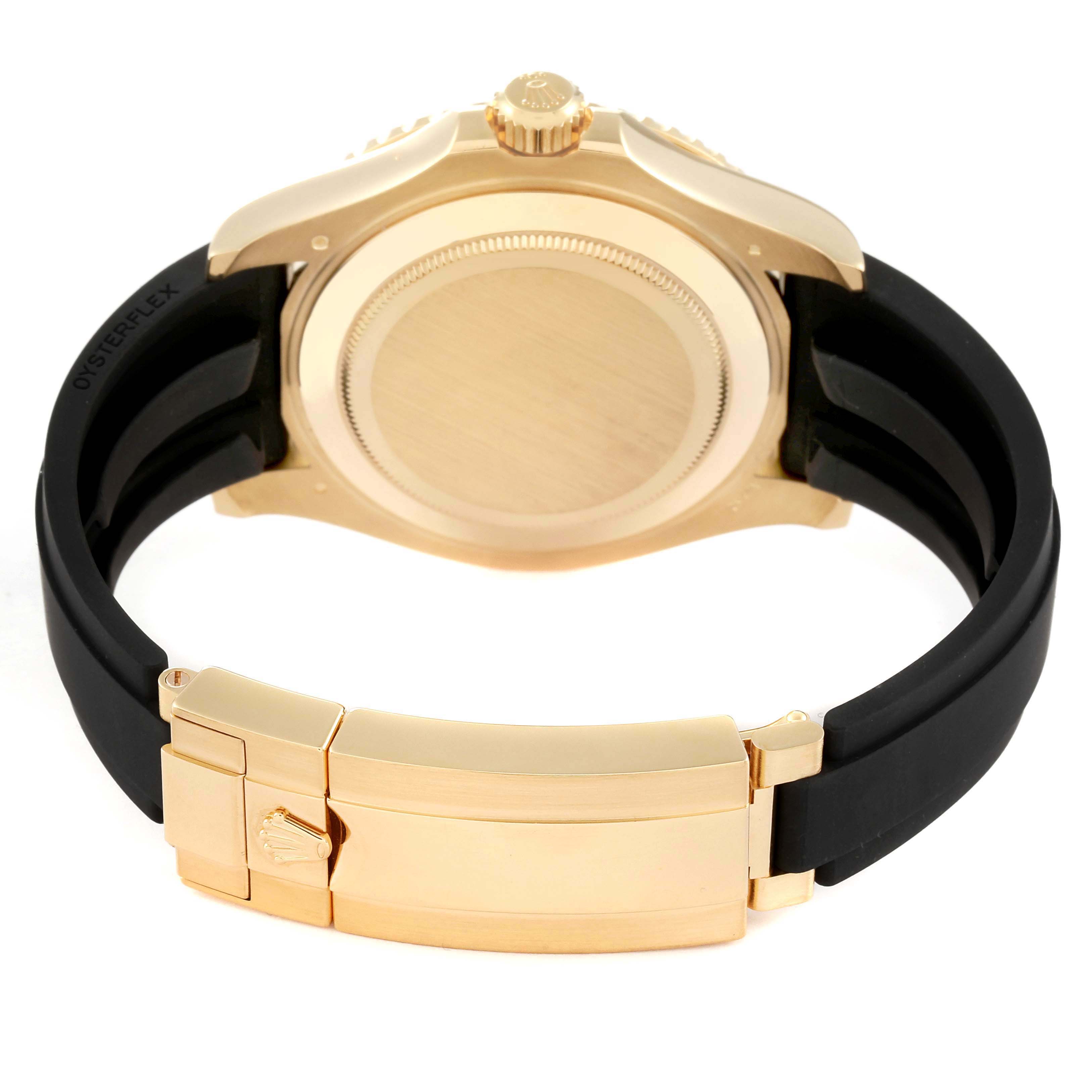 The image shows the back view of a Rolex Yacht-Master 226658 Men's Yellow Gold Black Dial 226658 Men's Yellow Gold Black Dial watch, featuring its gold case, crown, and black rubber strap with a clasp.