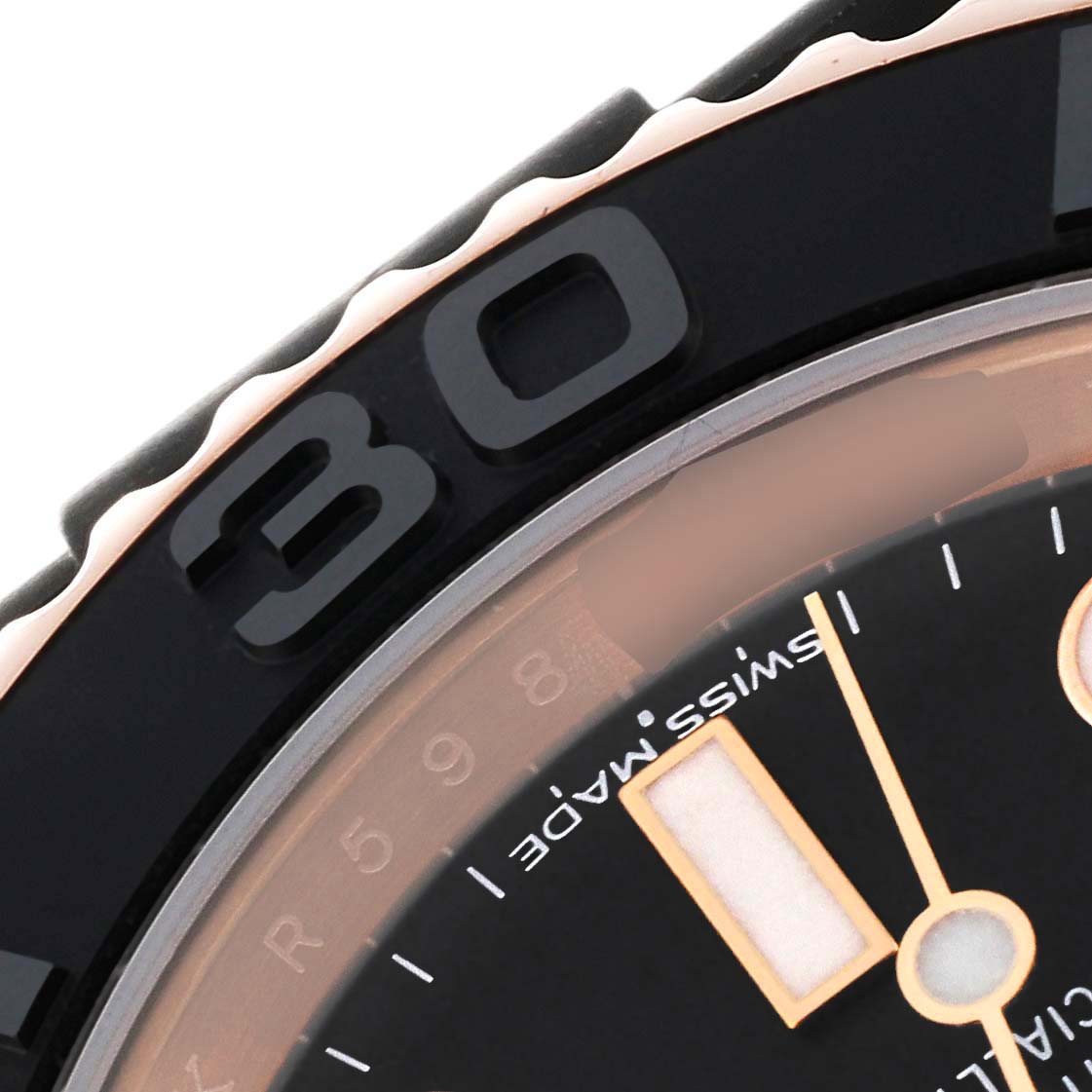 This close-up image of a Rolex Yacht-Master 116655 Men's Rose Gold Black Dial 116655 Men's Rose Gold Black Dial watch shows part of the bezel, dial, and hands.