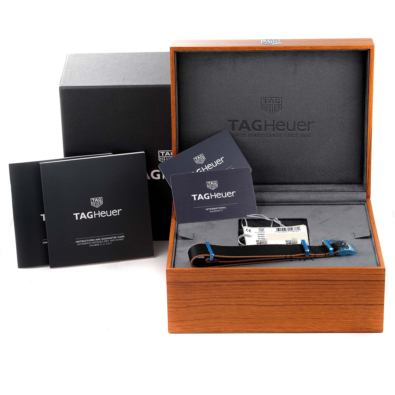 The image shows an open box of the Tag Heuer Autavia WBE5114.EB0173 Men's Stainless Steel Brown Dial WBE5114.EB0173 Men's Stainless Steel Brown Dial watch, including manuals, guarantee cards, and the watch strap.