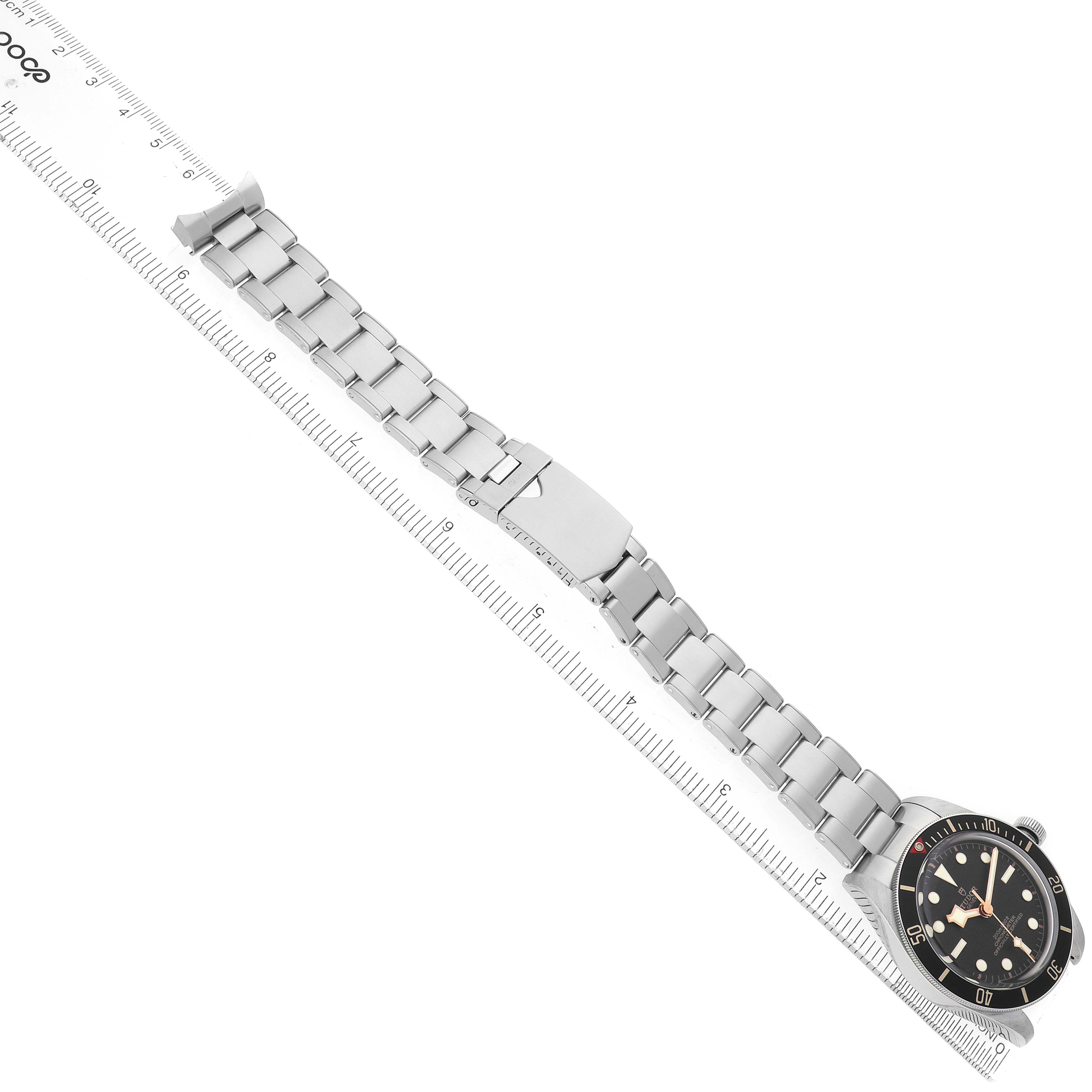 The image shows a Tudor Heritage Black Bay M79030N-0001 Men's Stainless Steel Black Dial watch laid flat, displaying the bracelet, clasp, and watch face.