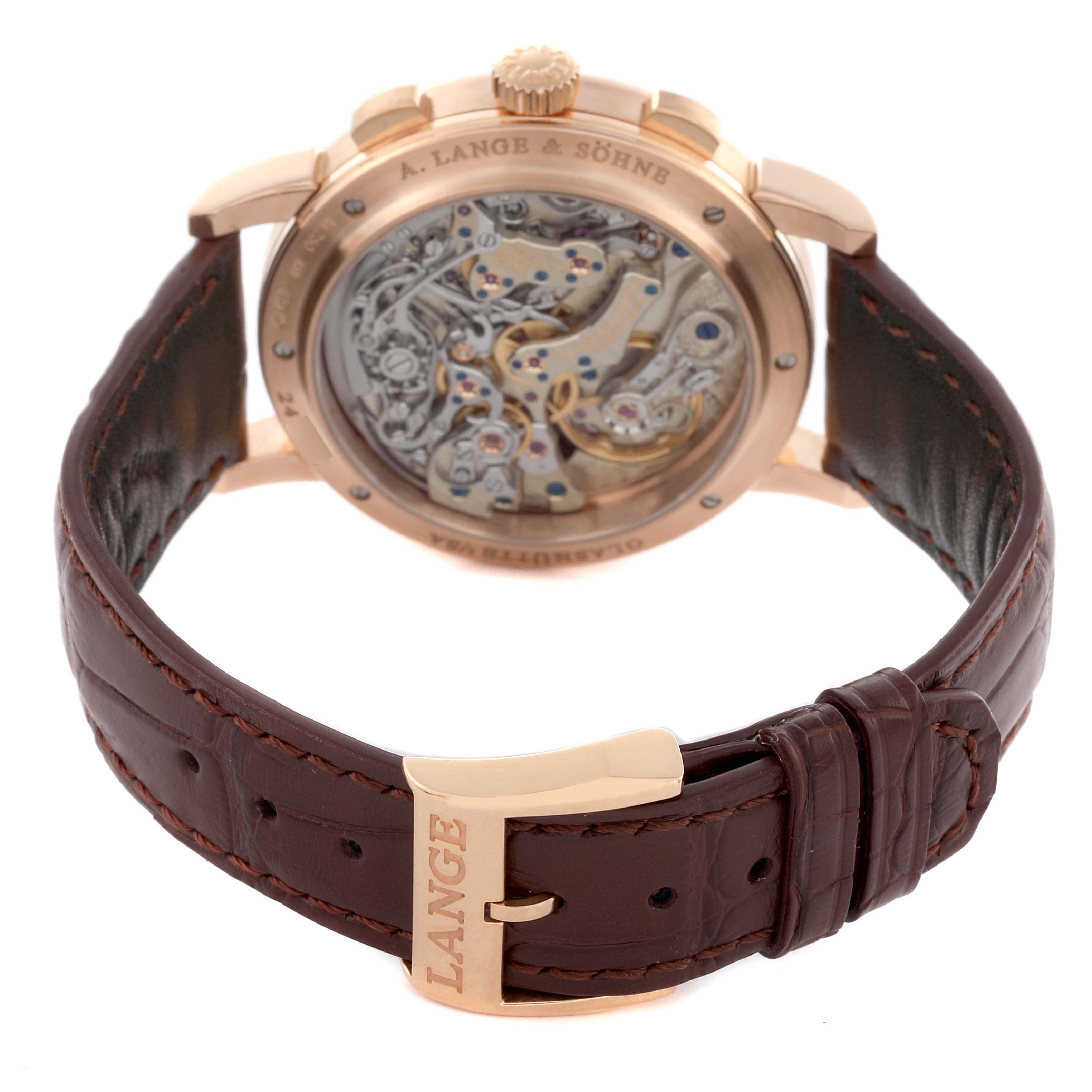 The A. Lange 
Sohne 1815 414.032 Men
s Rose Gold Silver Dial model is shown from the back, displaying its intricate movement and brown leather strap.