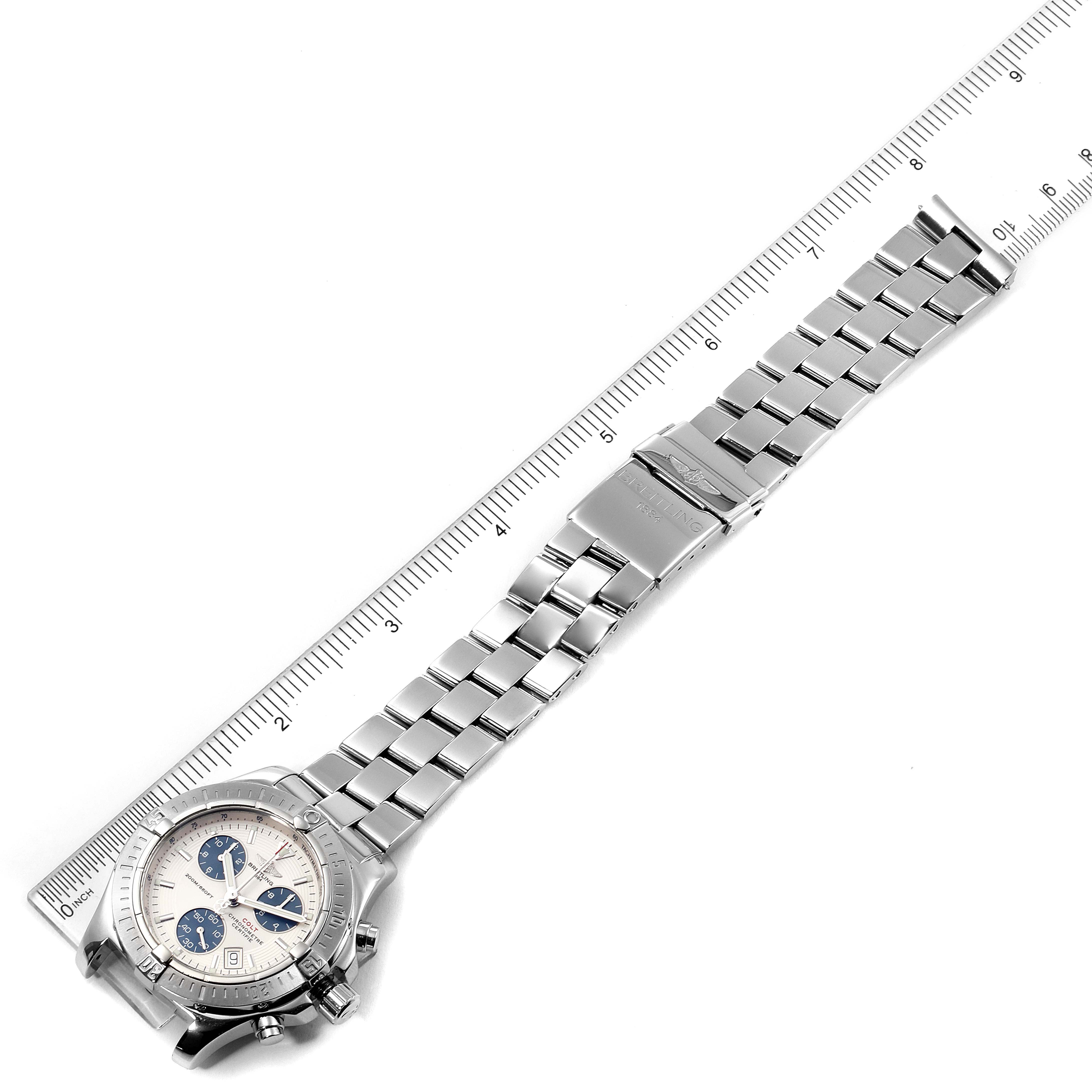 The image shows a Breitling Colt A73380 Men's Stainless Steel White Dial A73380 Men's Stainless Steel White Dial watch horizontally alongside a ruler, displaying the band and face from a top-down angle.