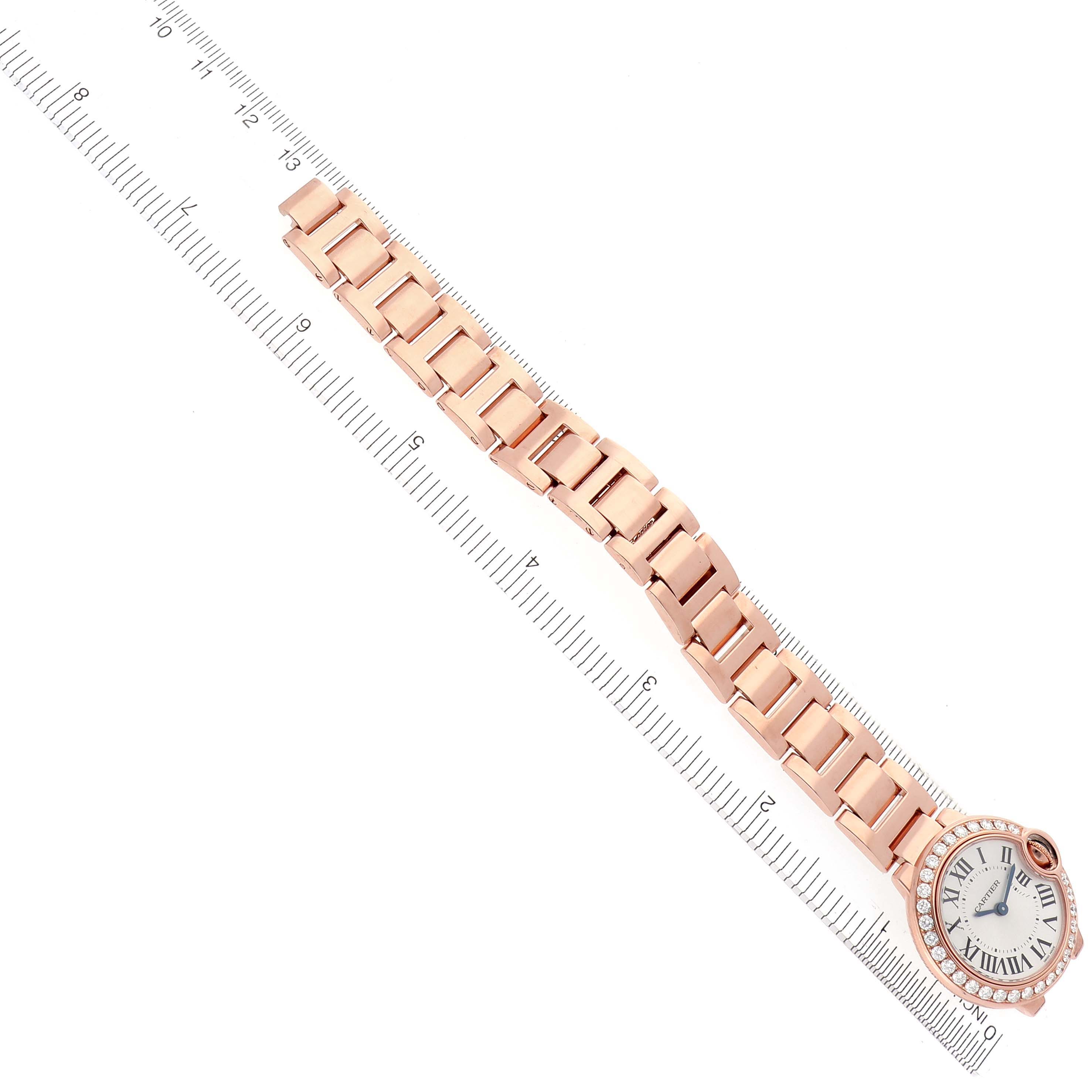 The Cartier Ballon Bleu WE9002Z3 Women's Rose Gold Silver Dial WE9002Z3 Women's Rose Gold Silver Dial watch is shown horizontally with its bracelet and face visible, alongside a ruler for scale.