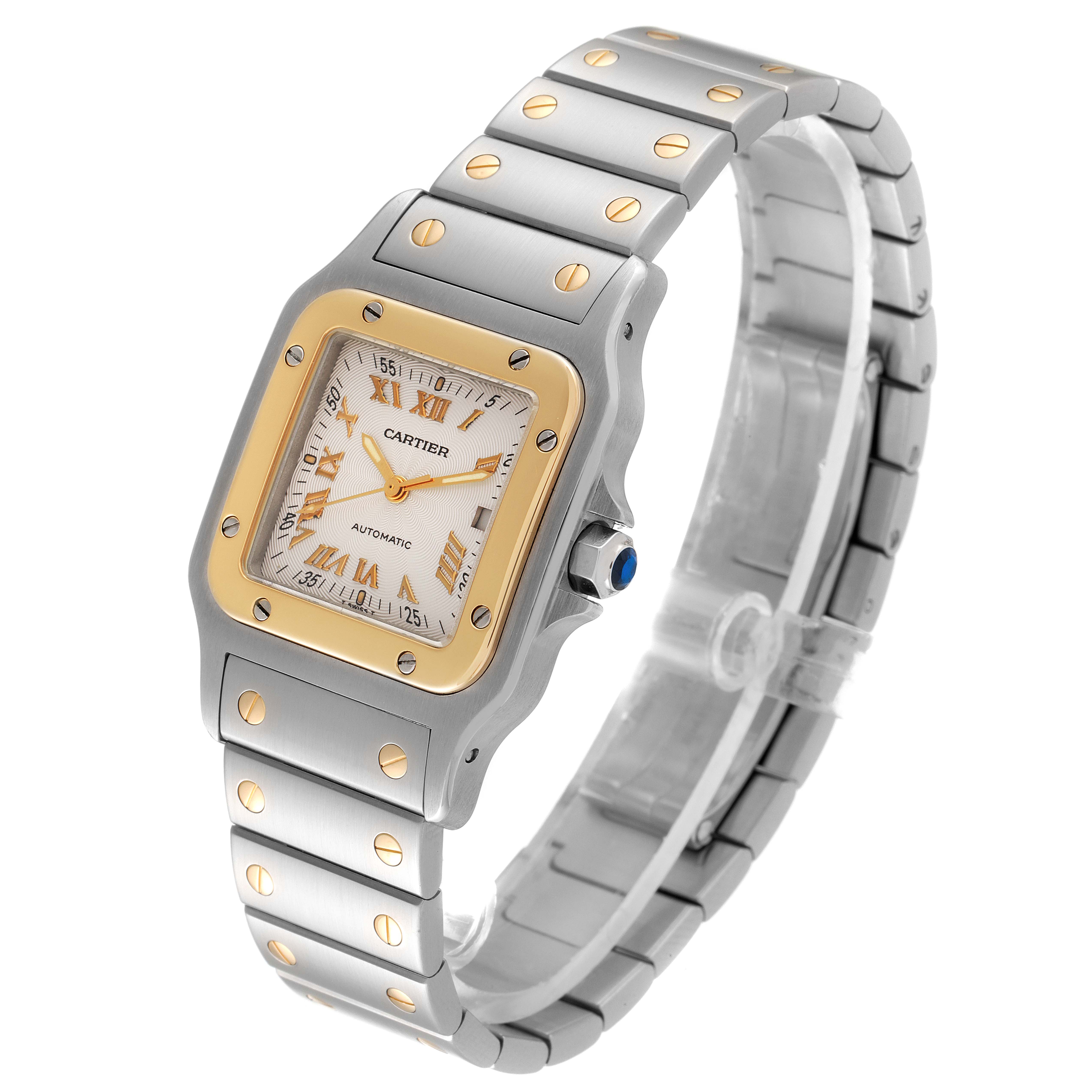 The Cartier Santos W20058C4 Men's Steel and Gold (two tone) Silver Dial W20058C4 Men's Steel and Gold (two tone) Silver Dial watch is shown from an angled view, displaying its two-tone metal casing, bracelet, and Roman numeral dial.
