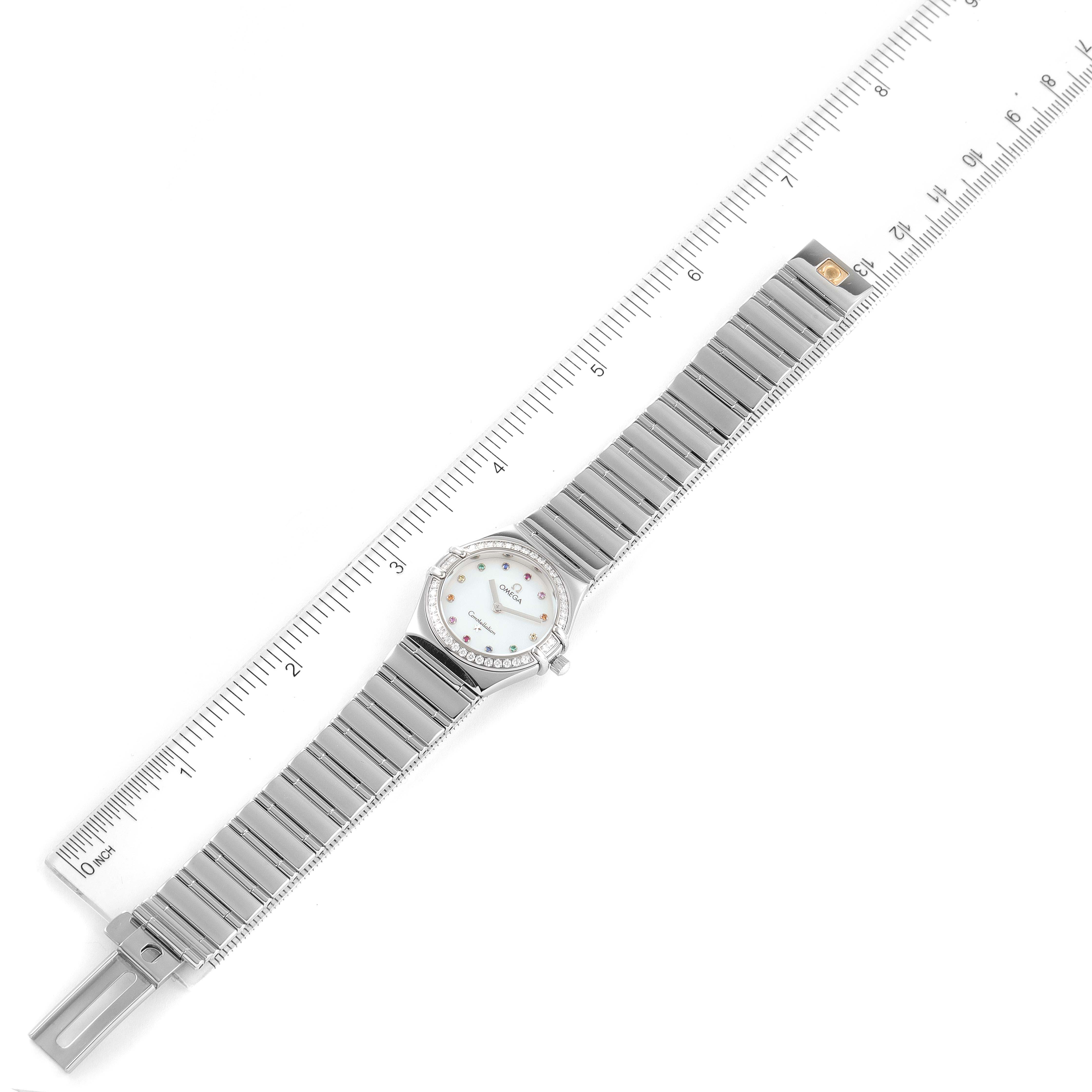 The image shows the Omega 1475.79.00 Women's Stainless Steel Mother of Pearl Dial 1475.79.00 Women's Stainless Steel Mother of Pearl Dial Constellation Iris Steel Multi Stone Ladies Watch 1475.79.00 laid flat with a ruler for scale.