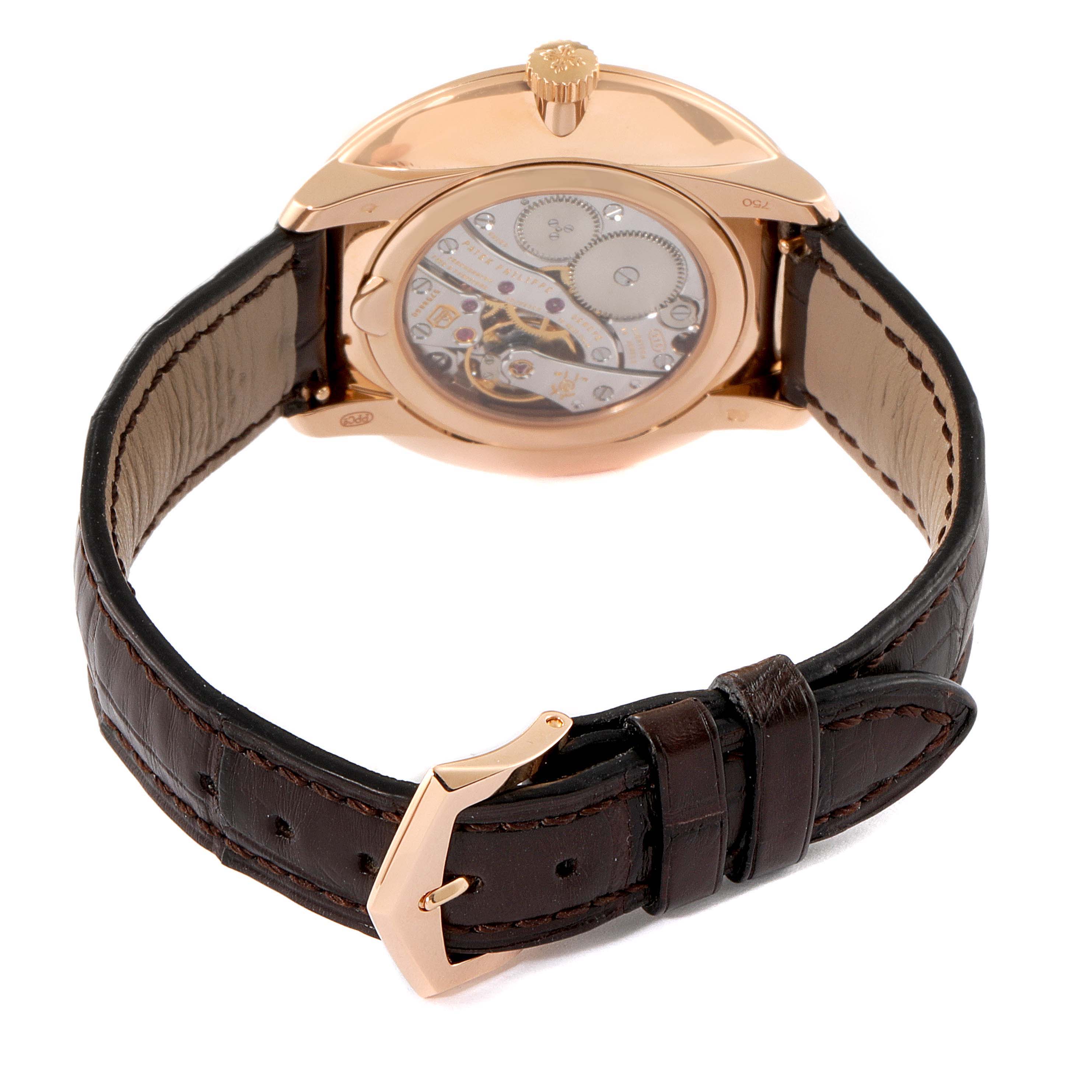 The image shows the Patek Philippe Calatrava 5123R-001 Men's Rose Gold Silver Dial 5123R-001 Men's Rose Gold Silver Dial watch from a rear angle, displaying its movement through the transparent case back and leather strap with a buckle.