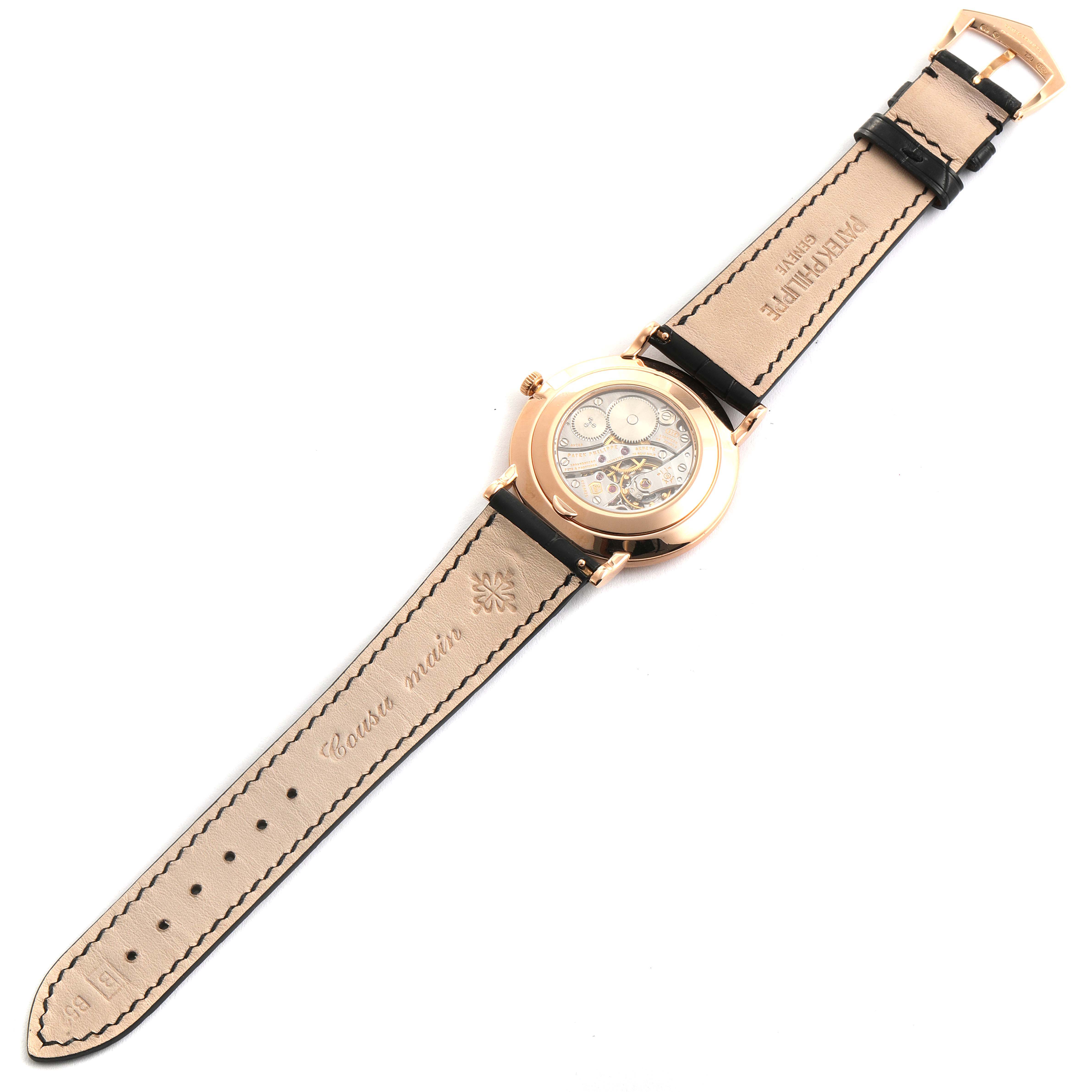 The image shows the back view and inner mechanism of a Patek Philippe Calatrava 5119R Men's Rose Gold White Dial 5119R Men's Rose Gold White Dial watch laid flat, revealing its strap and buckle.