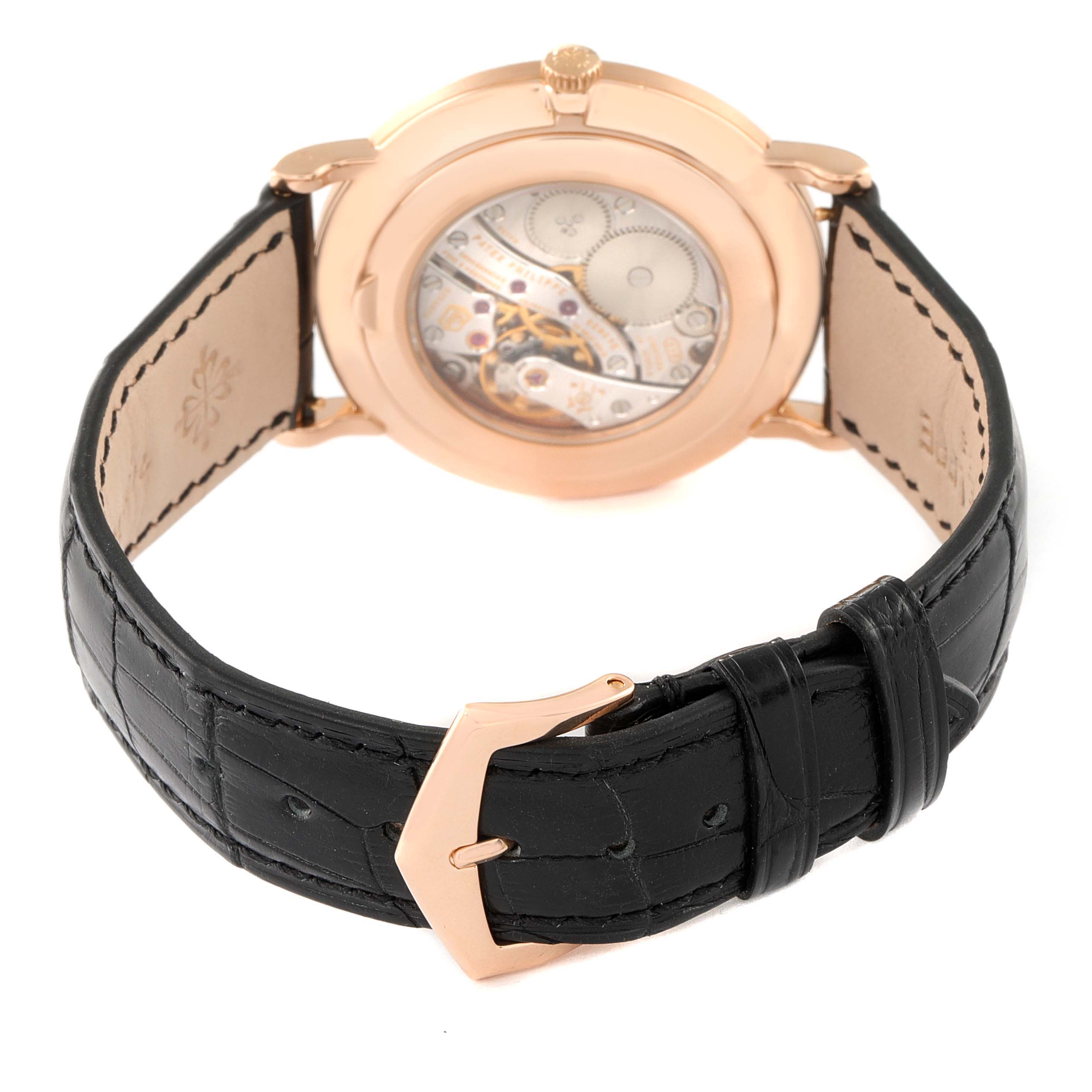 The image shows the back view of a Patek Philippe Calatrava 5119R Men's Rose Gold White Dial 5119R Men's Rose Gold White Dial watch, highlighting its movement and black leather strap.
