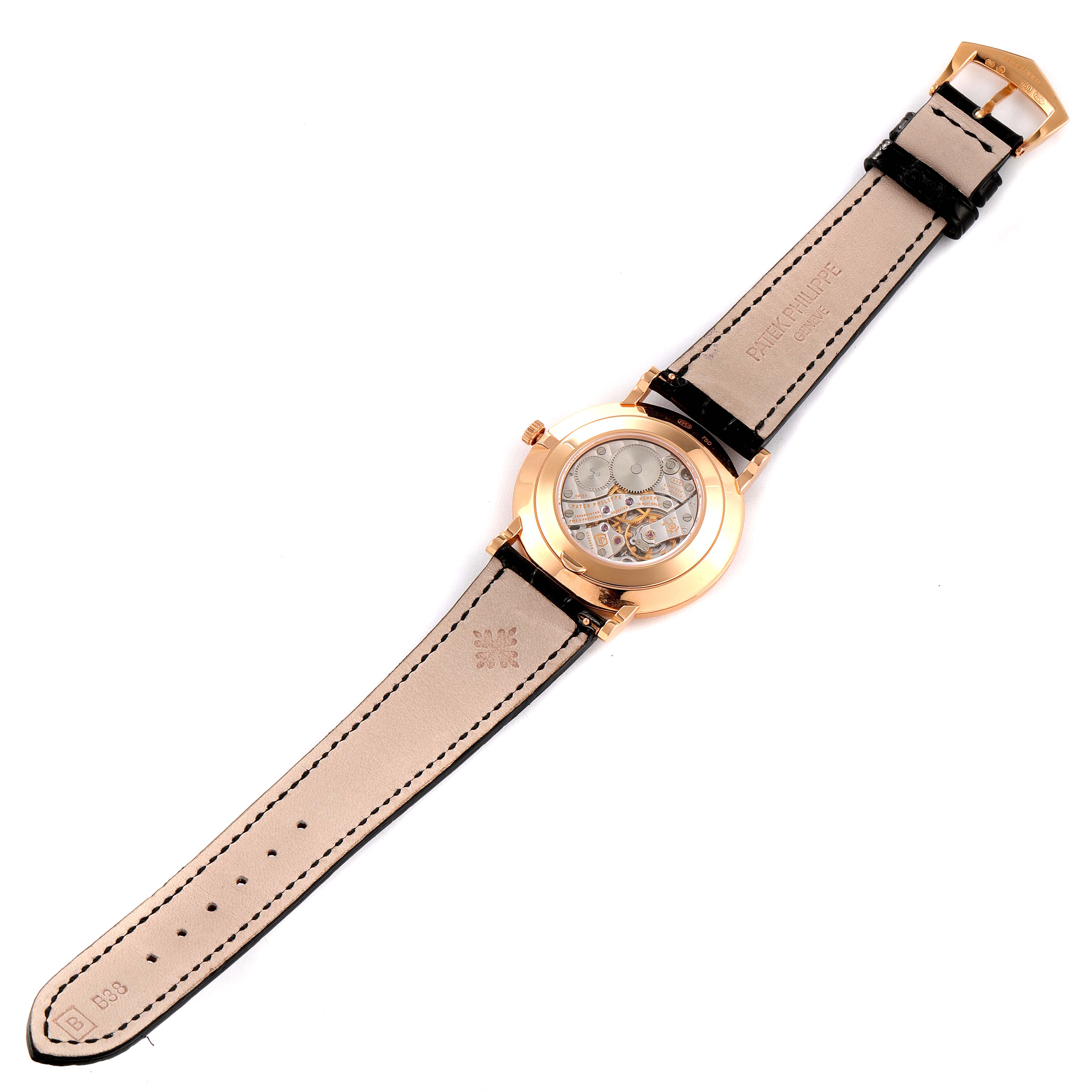 The image shows the back view of a Patek Philippe Calatrava 5119R Men's Rose Gold White Dial 5119R Men's Rose Gold White Dial watch revealing the internal mechanism and the leather strap.