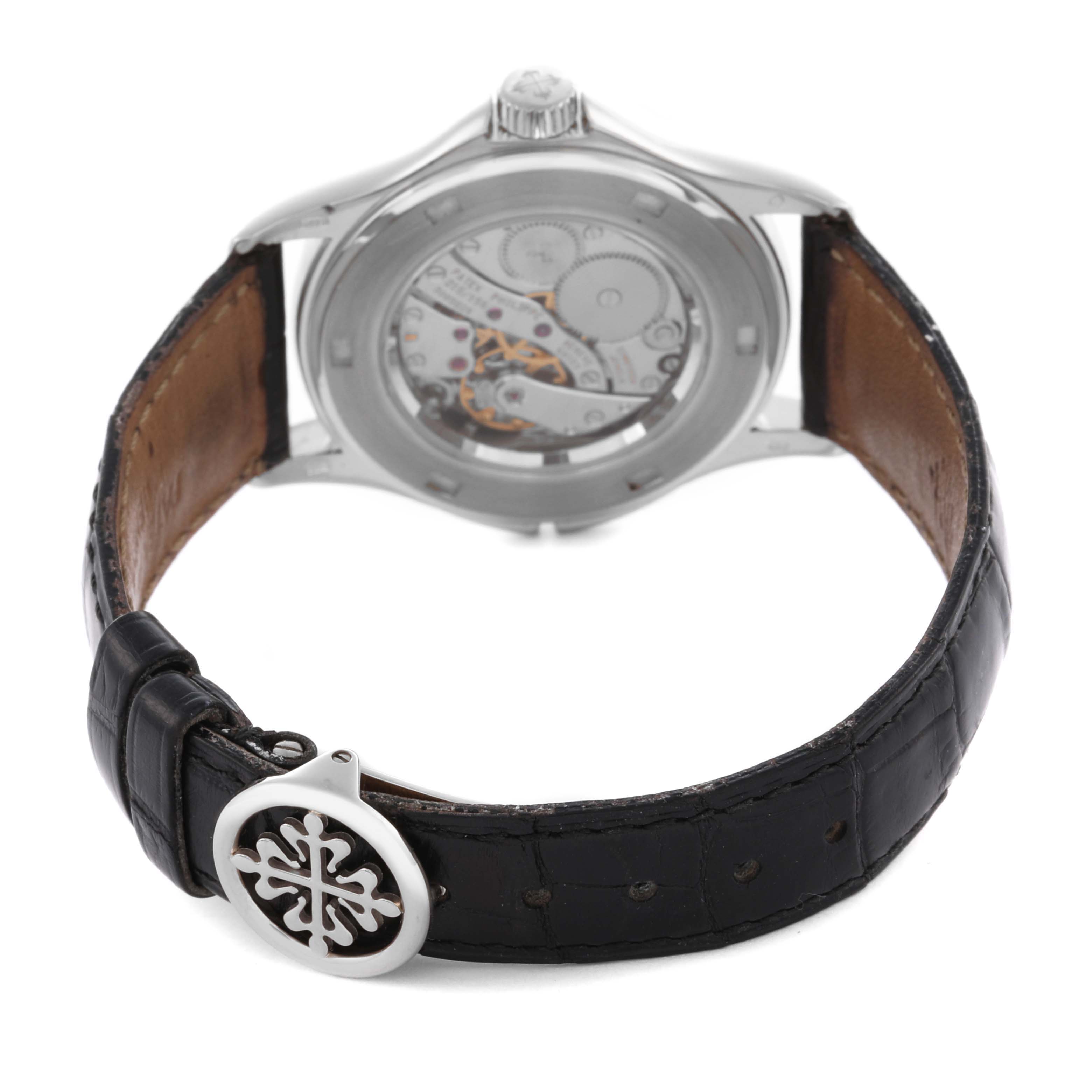 The image shows a Patek Philippe Calatrava 5134G Men's White Gold White Dial 5134G Men's White Gold White Dial watch from the rear, highlighting the movement and leather strap with the clasp visible.