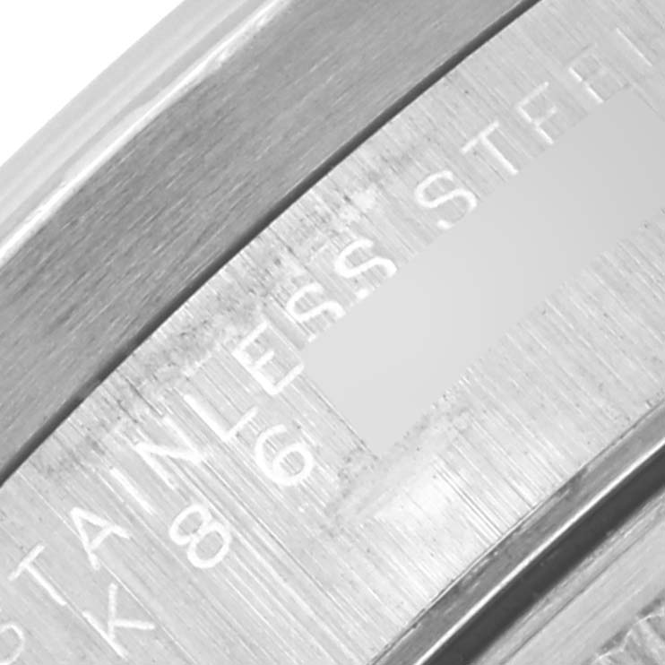 The image shows a close-up of the inner case engraving on a Rolex Date 15210 Men's Stainless Steel Blue Dial 15210 Men's Stainless Steel Blue Dial model, highlighting "STAINLESS STEEL."