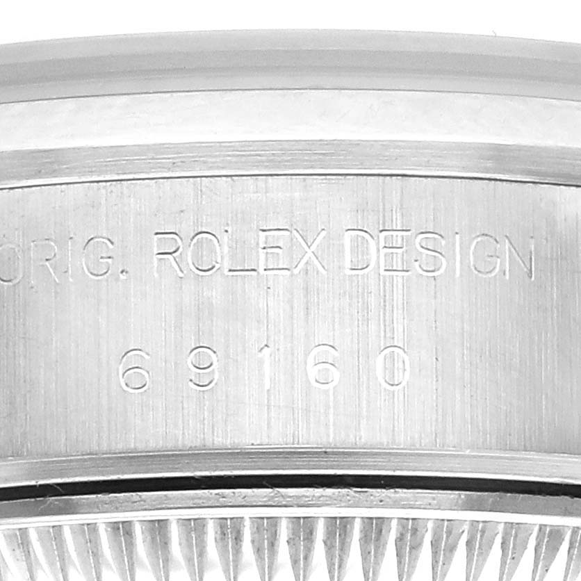The image shows the side engraving of a Rolex Date 69160 Women's Stainless Steel Blue Dial 69160 Women's Stainless Steel Blue Dial model with the design and serial numbers visible.