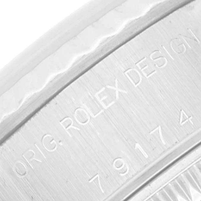 The image shows a close-up of the engraved case of a Rolex Datejust 79174 Women's Stainless Steel Silver Dial 79174 Women's Stainless Steel Silver Dial watch.