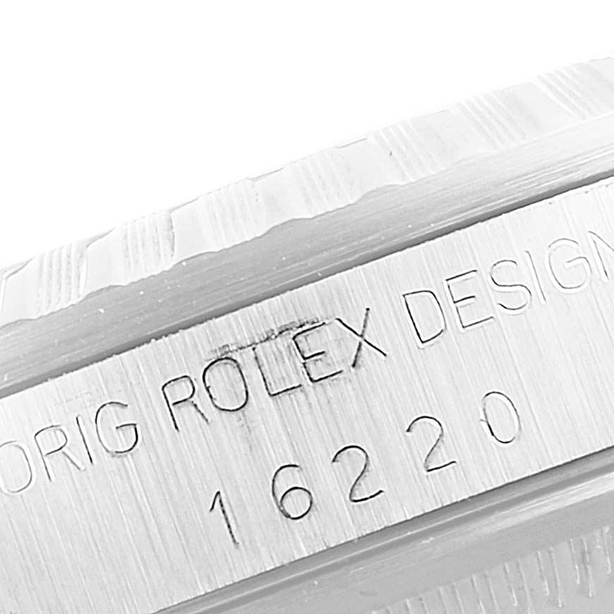 The image shows a close-up of the serial number engraving and fluted bezel on a Rolex Datejust 16220 Men
s Stainless Steel Blue Dial 16220 Men
s Stainless Steel Blue Dial model watch.