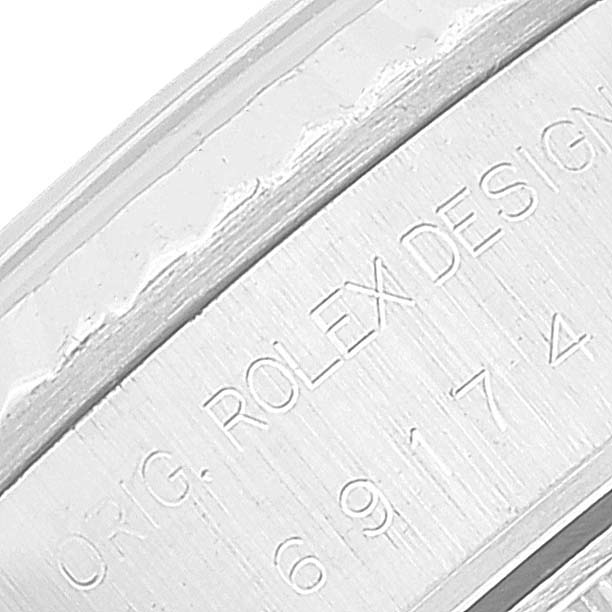 A close-up of the serial number and "Rolex Design" engraving inside the case of a Rolex Datejust 69174 Women's Stainless Steel White Dial 69174 Women's Stainless Steel White Dial watch.