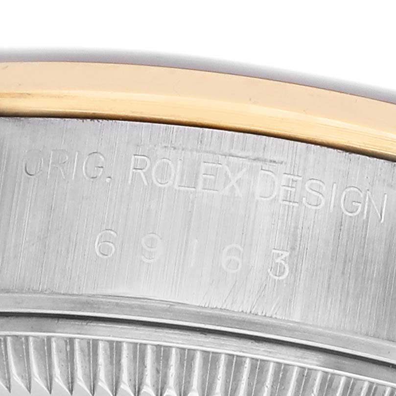 The image shows a close-up of the side of a Rolex Datejust 69163 Women's Steel and Gold (two tone) Black Dial, focusing on its bezel and engraved model number.