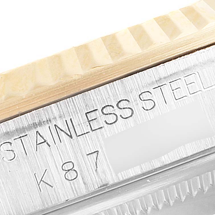 This image shows a close-up of the bezel and the side of the case of a Rolex Datejust 16233 Men
s Steel and Gold (two tone) Mother of Pearl Dial 16233 Men
s Steel and Gold (two tone) Mother of Pearl Dial, highlighting the "STAINLESS STEEL" engraving.