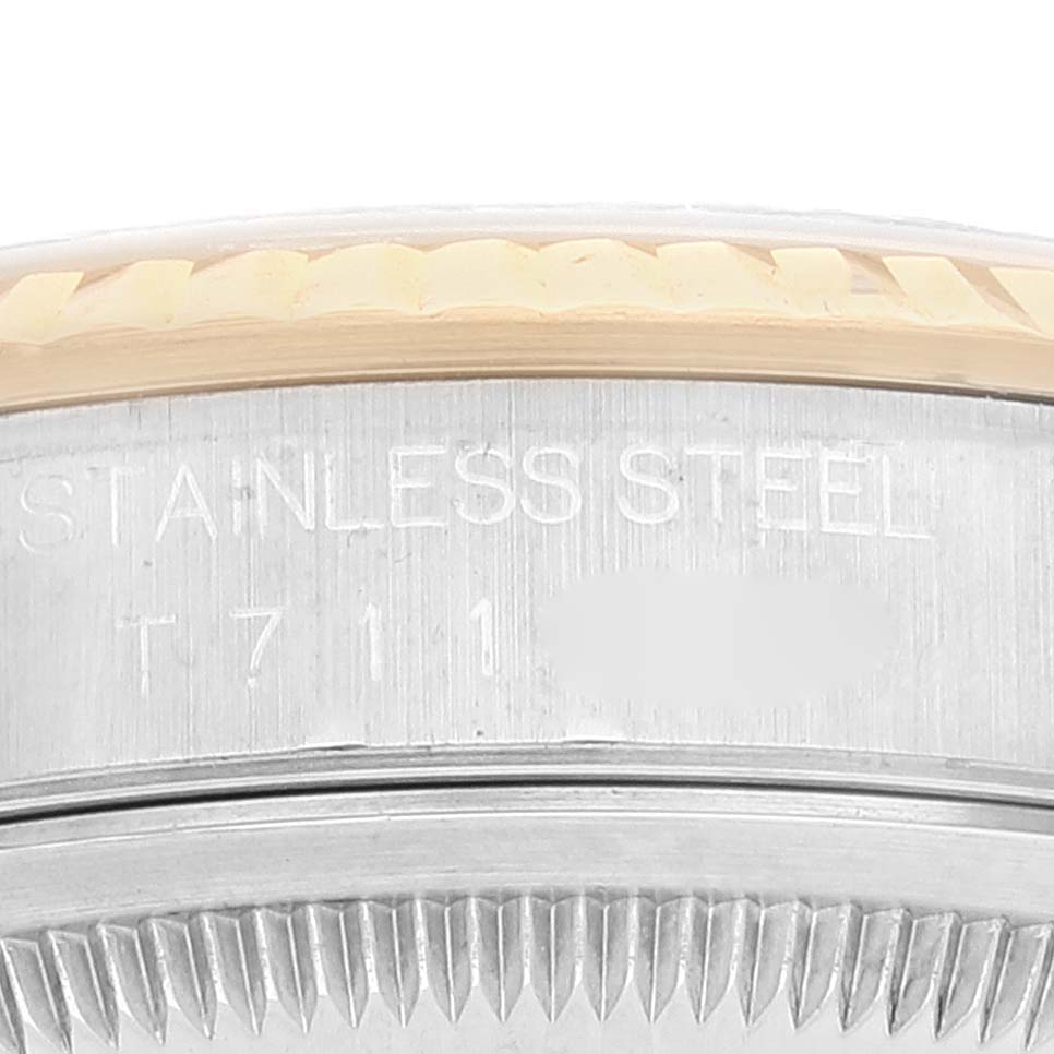 This image shows a close-up of the Rolex Datejust 16233 Men's Steel and Gold (two tone) Silver Dial 16233 Men's Steel and Gold (two tone) Silver Dial watch casing and part of the bezel, with engraving visible.