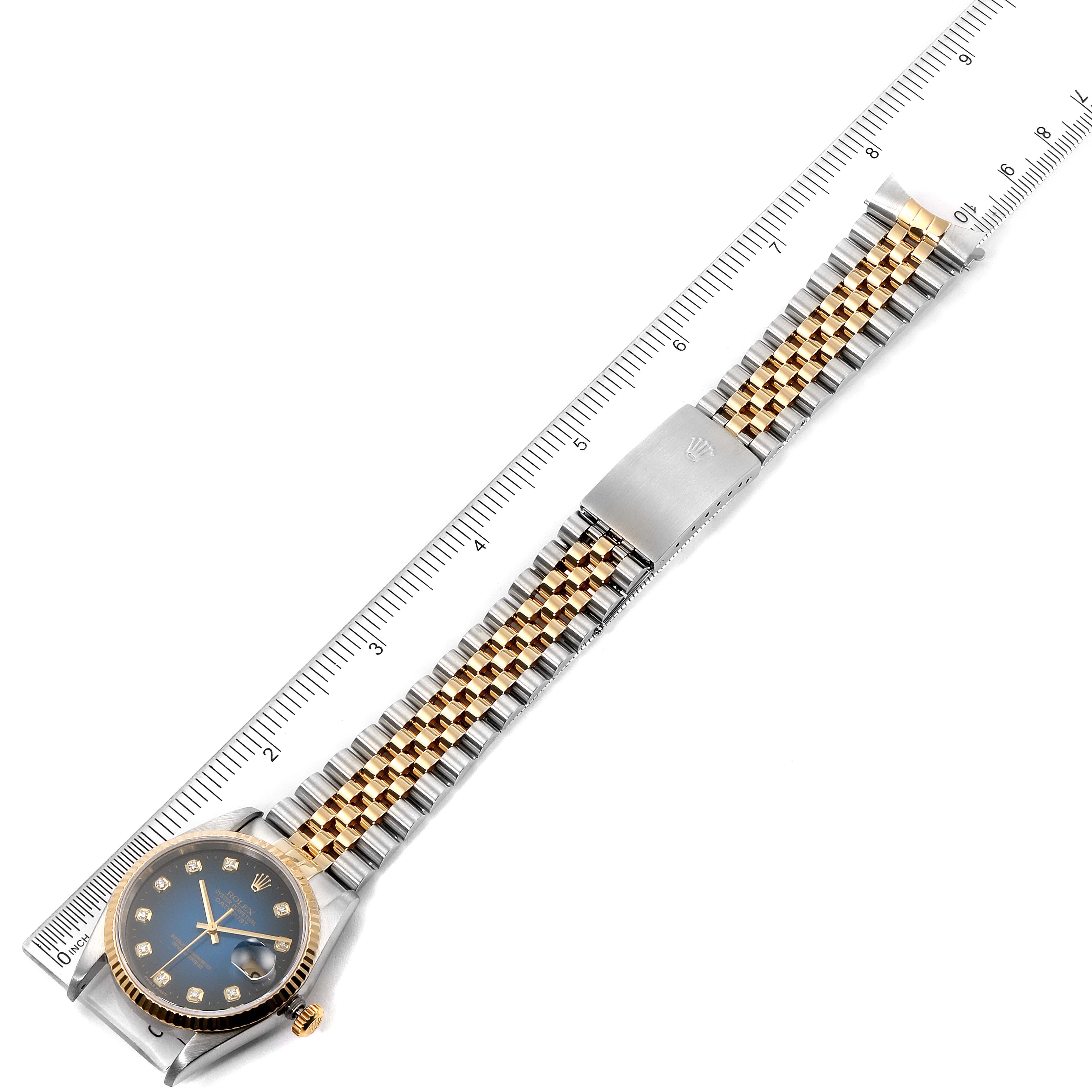 The image shows a Rolex Datejust 16233 Men's Steel and Gold (two tone) Blue Dial 16233 Men's Steel and Gold (two tone) Blue Dial watch laid flat with its dial, bezel, and two-tone bracelet visible, alongside a ruler for scale.