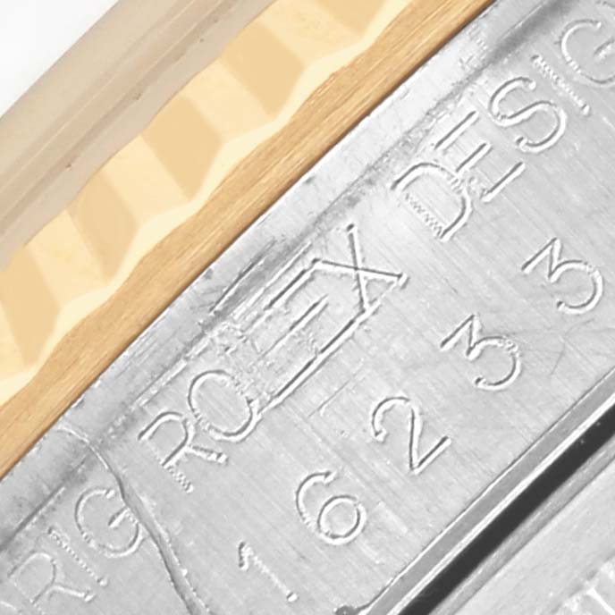 The image shows a close-up of the Rolex Datejust 16233 Men's Steel and Gold (two tone) White Dial 16233 Men's Steel and Gold (two tone) White Dial's fluted bezel and engraved inner ring.