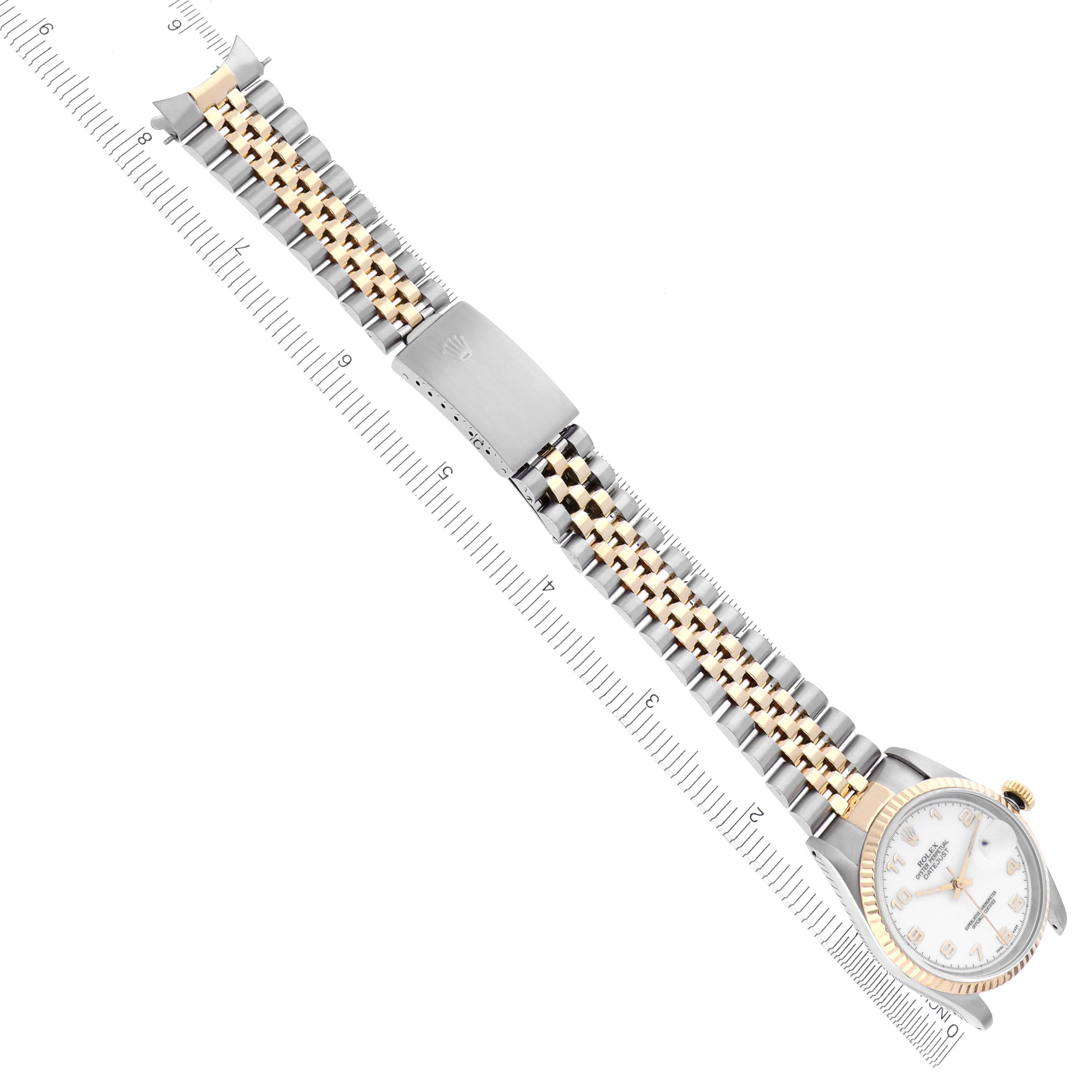 The Rolex Datejust 16233 Men's Steel and Gold (two tone) White Dial 16233 Men's Steel and Gold (two tone) White Dial watch is shown in a diagonal view, displaying the full bracelet and case, with a ruler for scale.