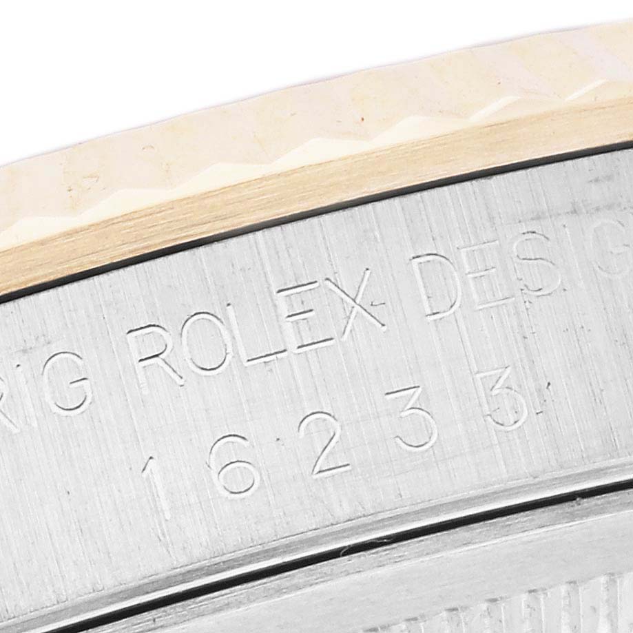 The image shows a close-up of the side of a Rolex Datejust 16233 Men's Steel and Gold (two tone) White Dial 16233 Men's Steel and Gold (two tone) White Dial watch case with engraved text and part of the bezel.