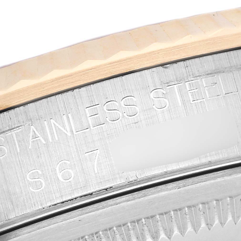 The image shows a close-up of the side of the bezel and engraving on the case back of a Rolex Datejust 16233 Men's Steel and Gold (two tone) White Dial 16233 Men's Steel and Gold (two tone) White Dial watch.
