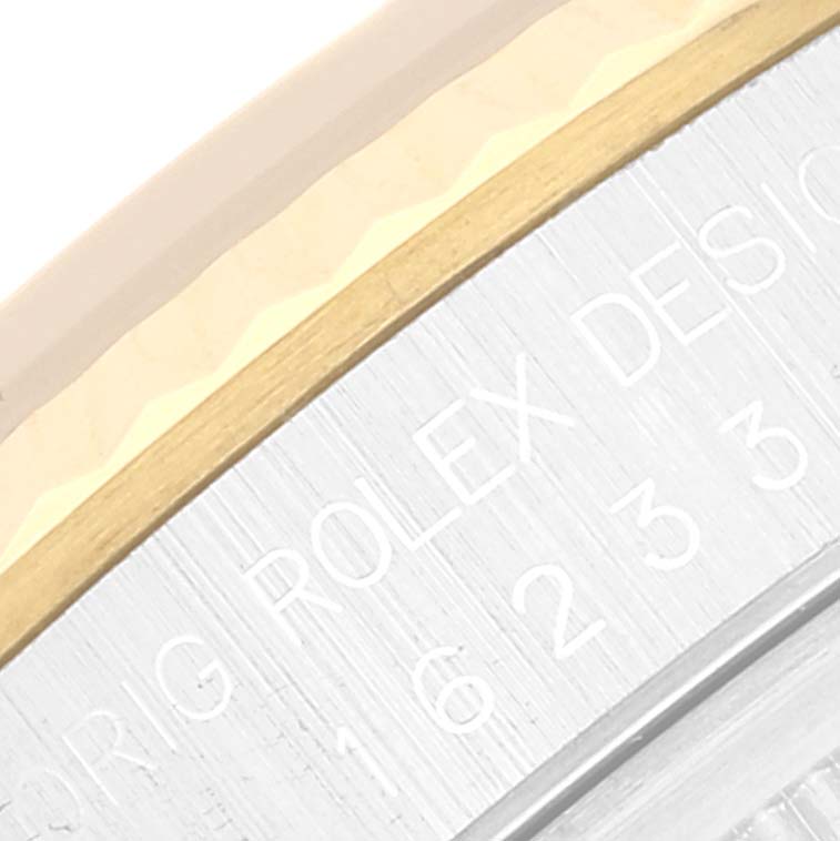 The image shows a close-up of the engraved side of a Rolex Datejust 16233 Men's Steel and Gold (two tone) White Dial 16233 Men's Steel and Gold (two tone) White Dial watch, featuring part of the bezel and case.