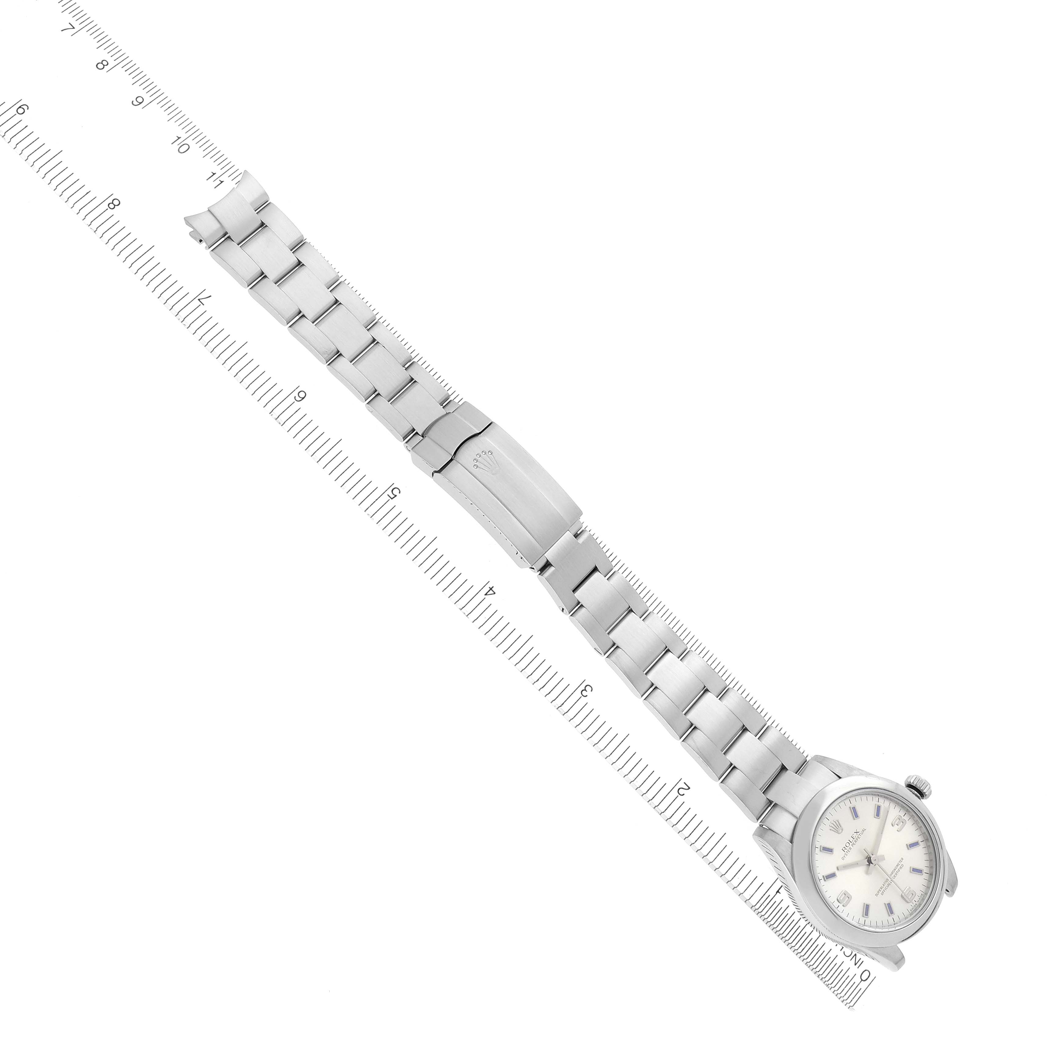 The Rolex Mid-Size 177200 Women
s Stainless Steel Silver Dial 177200 Women
s Stainless Steel Silver Dial watch is shown from a top-down angle featuring the face, band, and clasp, next to a ruler for scale.